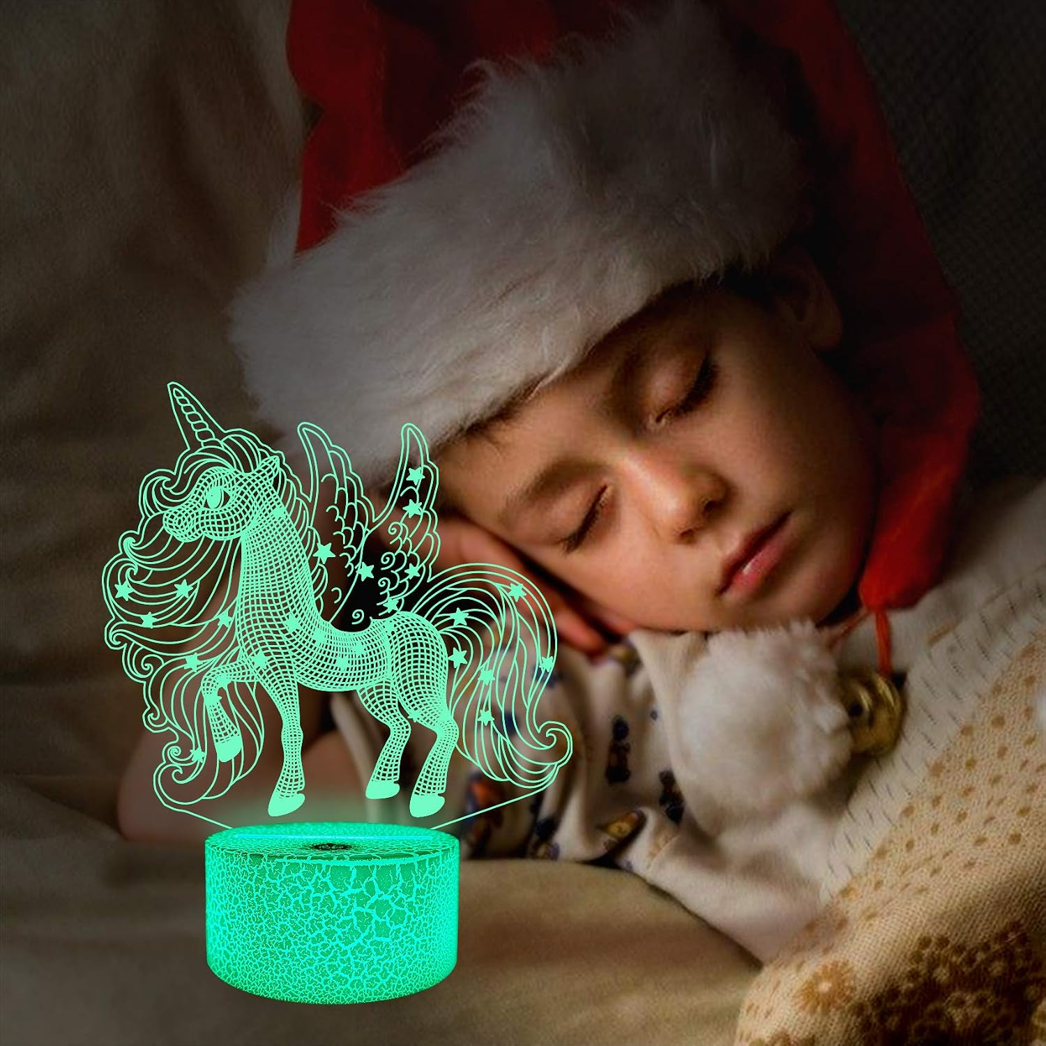 Ein Kind in einer Weihnachtsmütze schläft neben einem leuchtend grünen Einhorn-Nachtlicht.