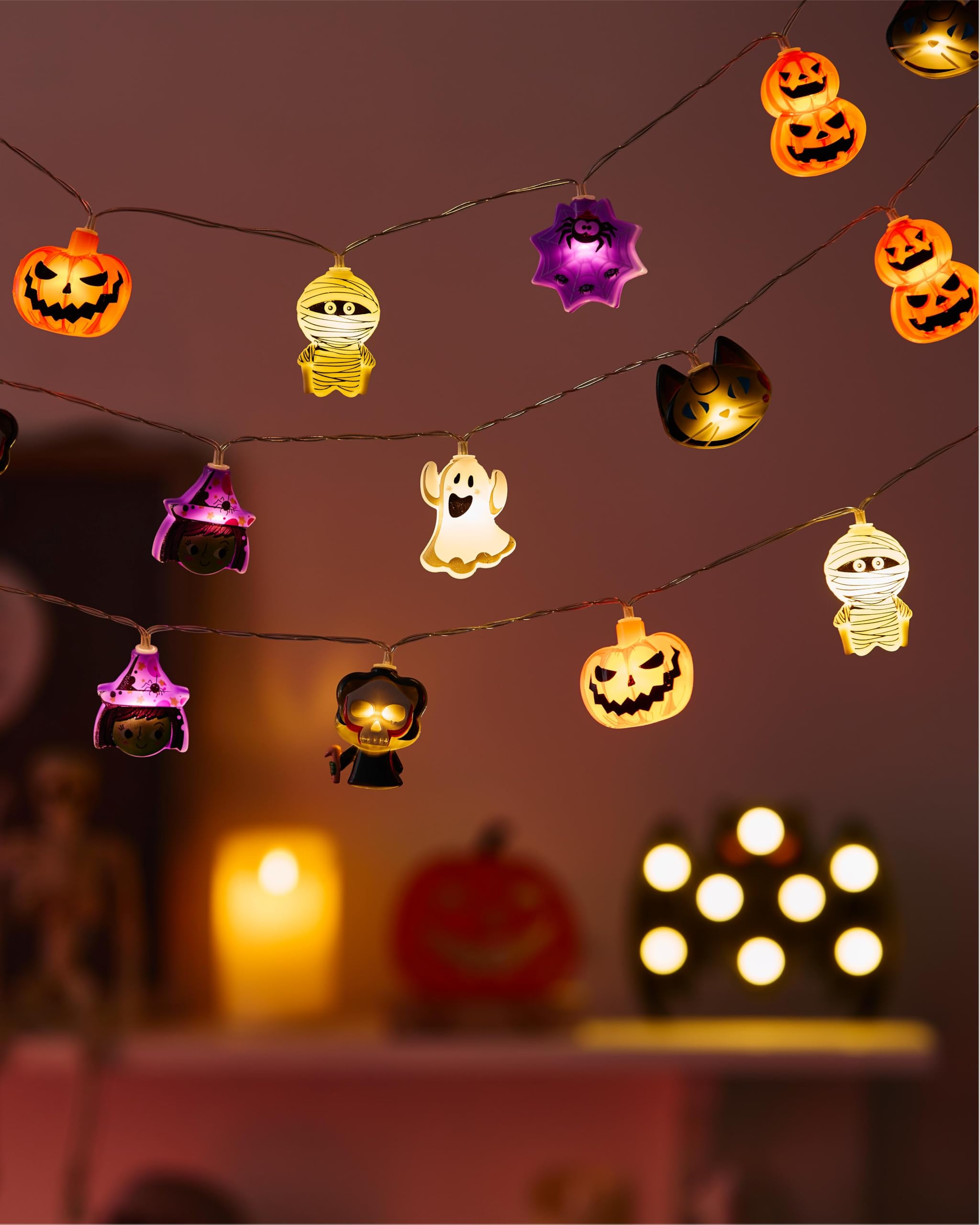 Leuchtende Halloween-Lichterkette mit Kürbissen, Geistern und Mumien in einem Raum.