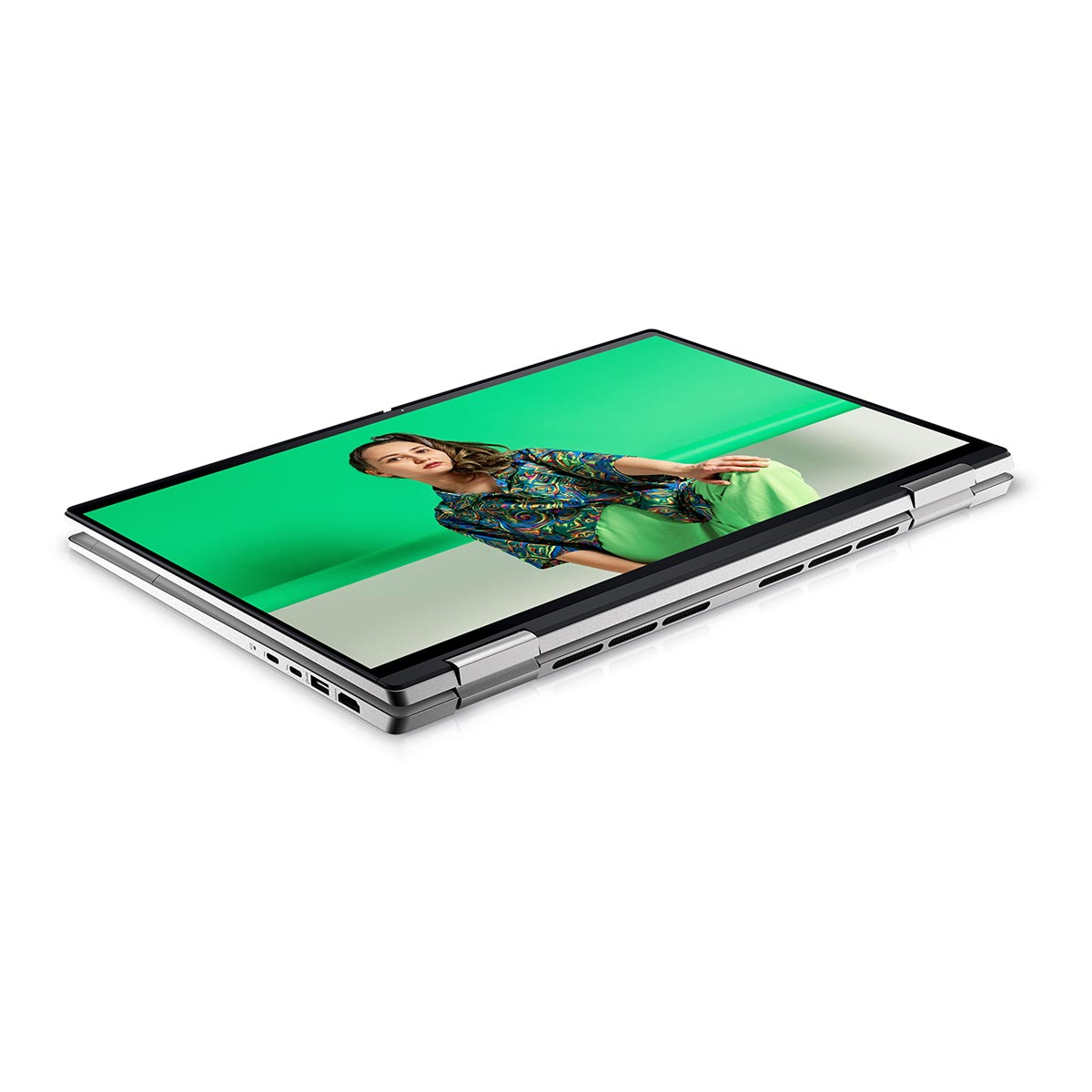 Srebrny laptop w trybie namiotu na białym tle, na ekranie widoczna kobieta.