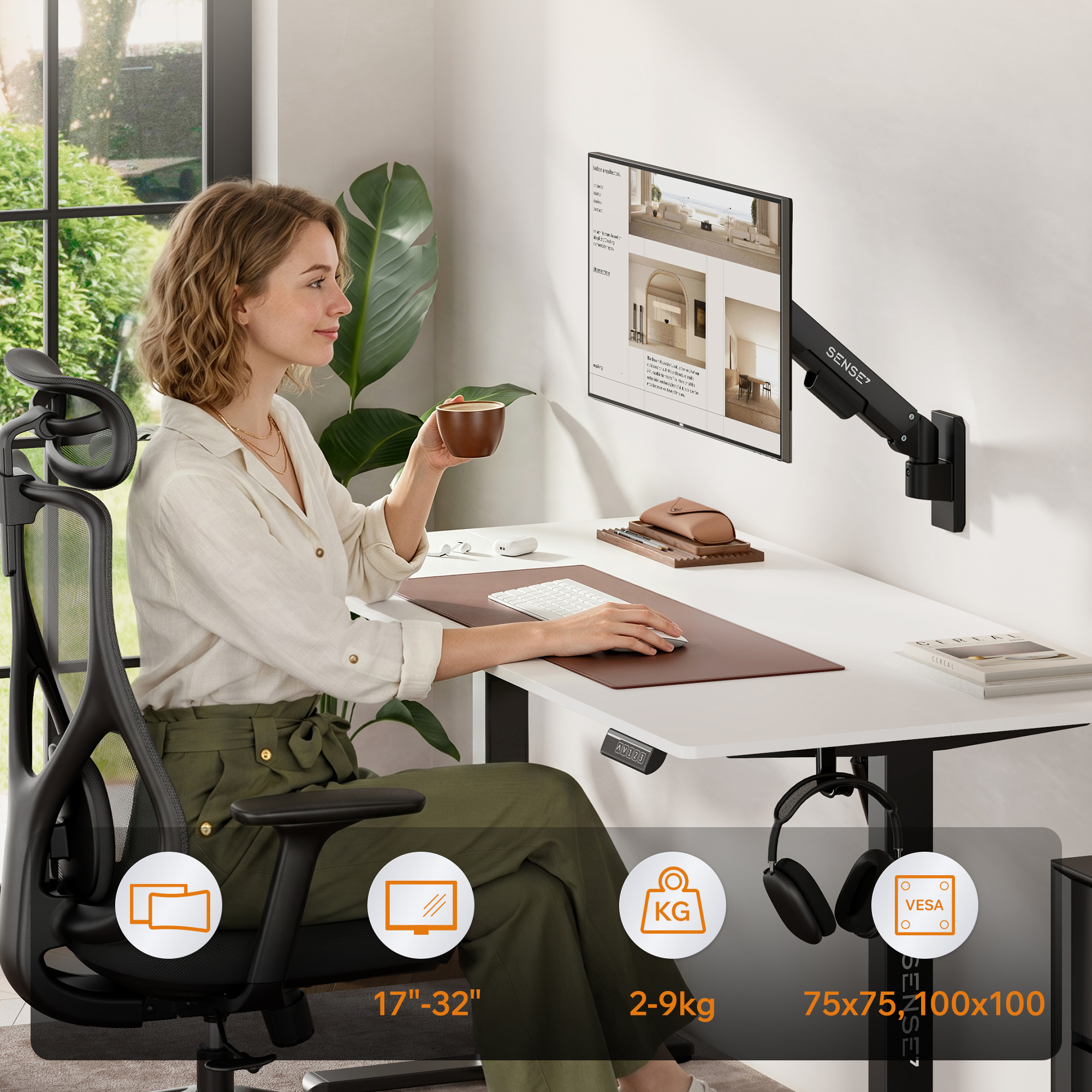 Eine Frau arbeitet an einem Schreibtisch mit Monitorarm, hält eine Tasse und tippt.