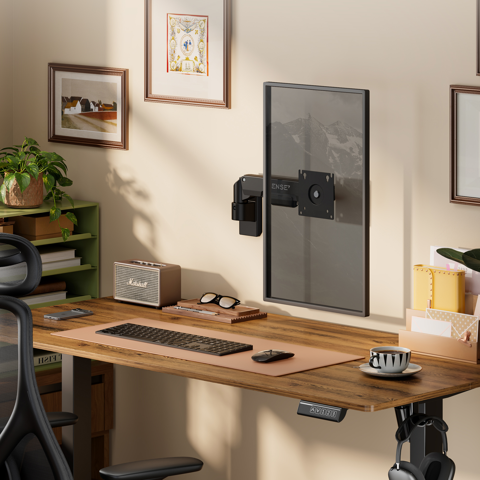 Ein Holztisch mit einem vertikalen Monitor an einem Arm, Tastatur, Maus, Kaffeetasse und gerahmter Kunst.