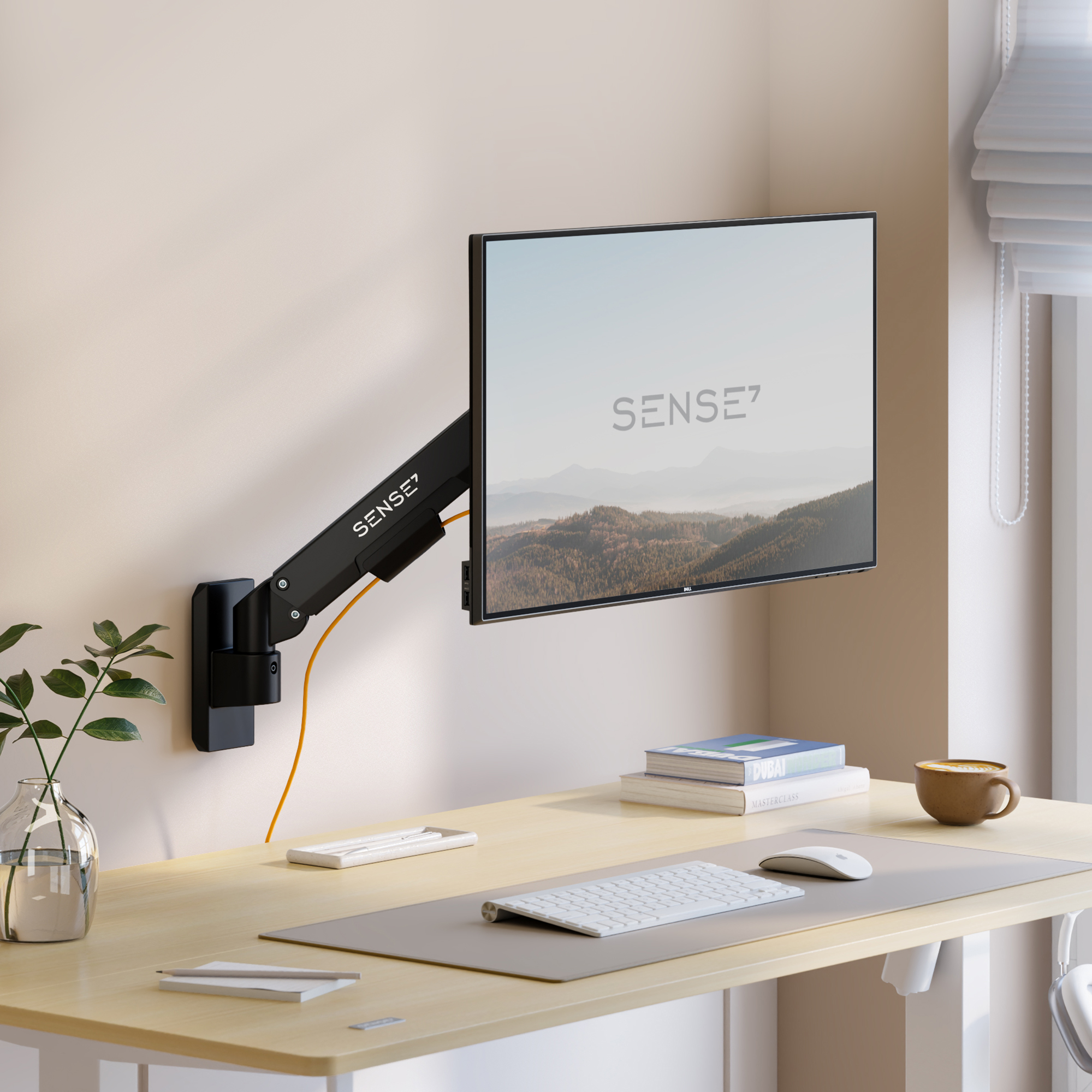 Ein an der Wand montierter schwarzer Monitorarm hält einen Bildschirm über einem Schreibtisch mit Tastatur und Pflanze.