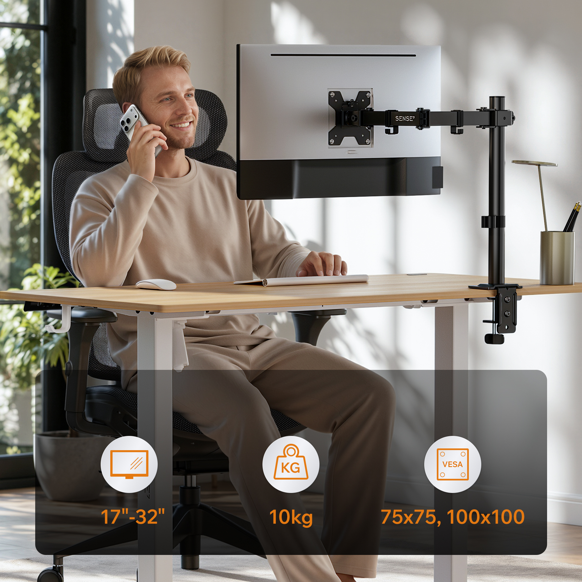 Mann telefoniert am Schreibtisch mit Monitorarm.