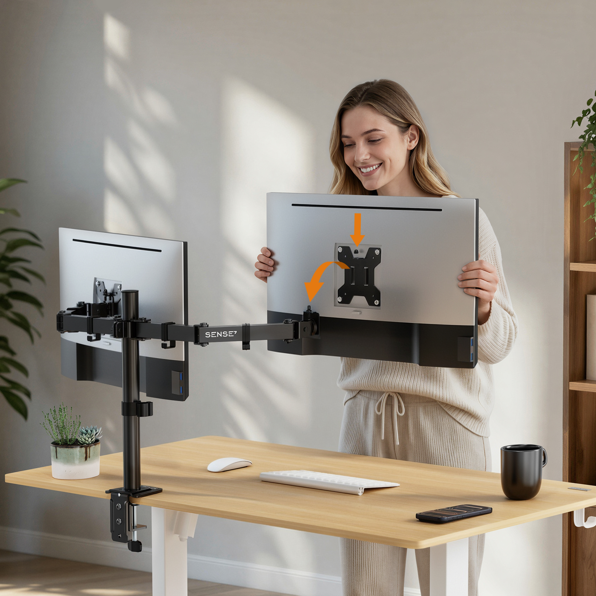 Eine Frau montiert einen Monitor an einem verstellbaren Arm auf einem Holztisch.