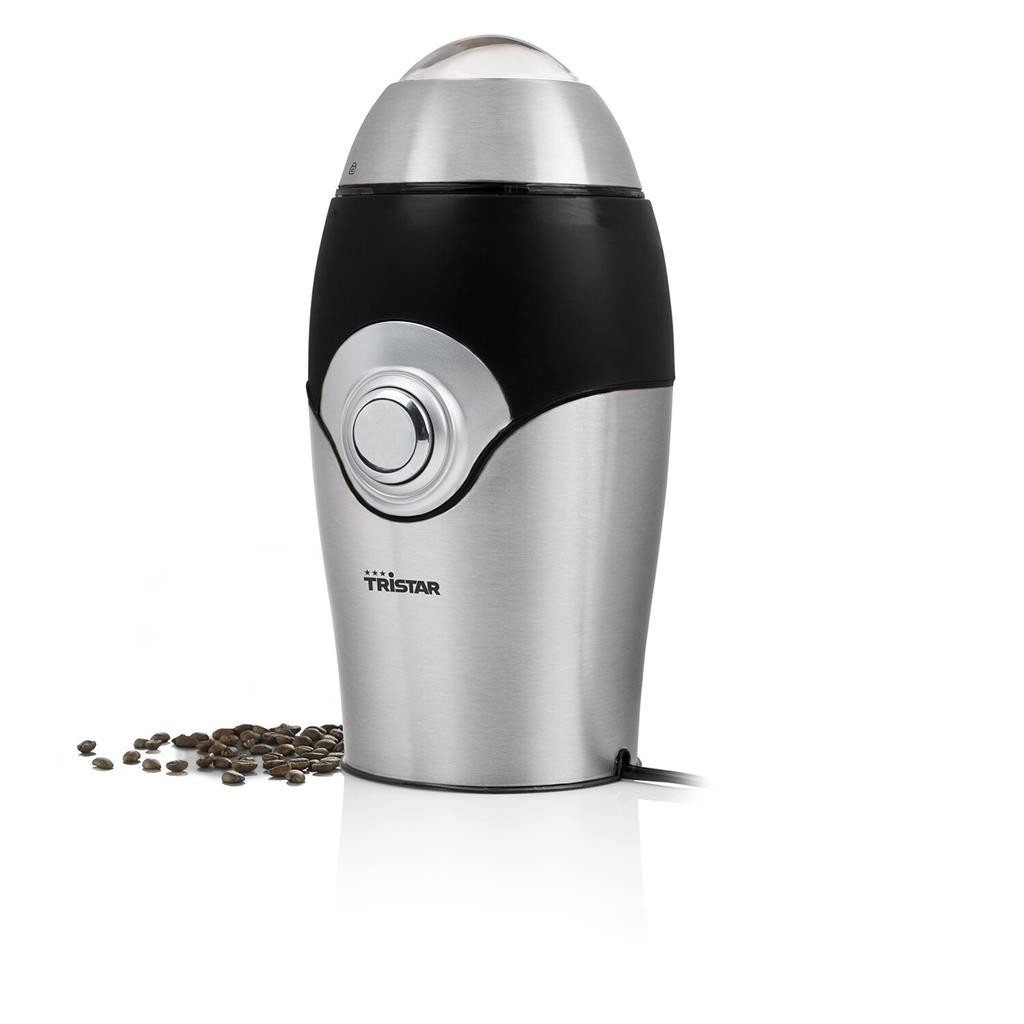 Eine silber-schwarze elektrische Kaffeemühle von Tristar steht auf weißem Grund mit Kaffeebohnen daneben.