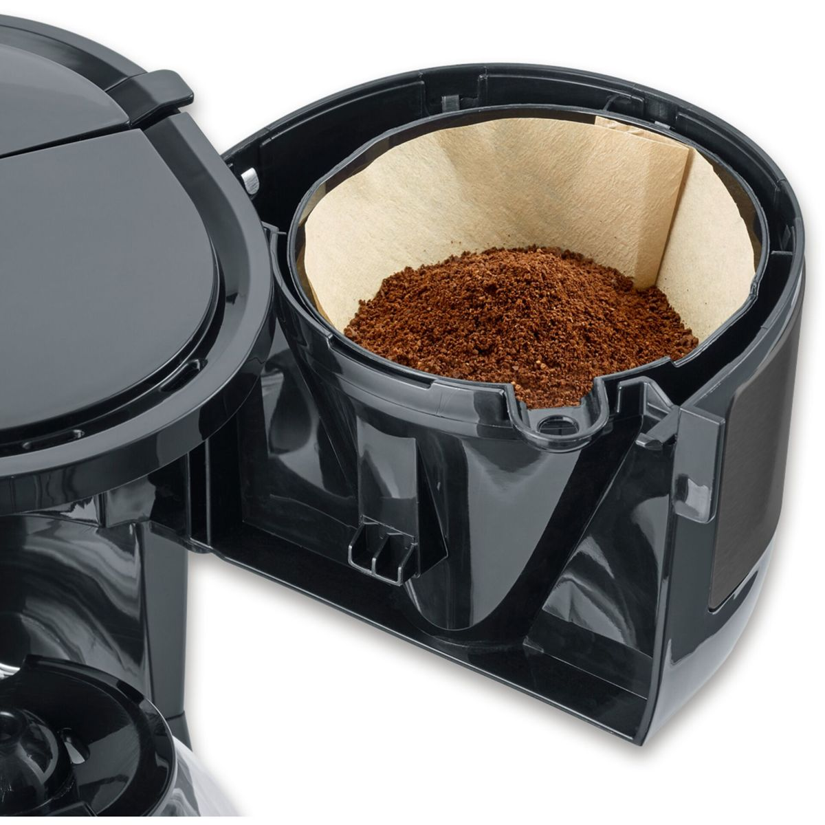 Una macchina da caffè nera con un portafiltro aperto, pieno di carta da filtro marrone e caffè macinato.