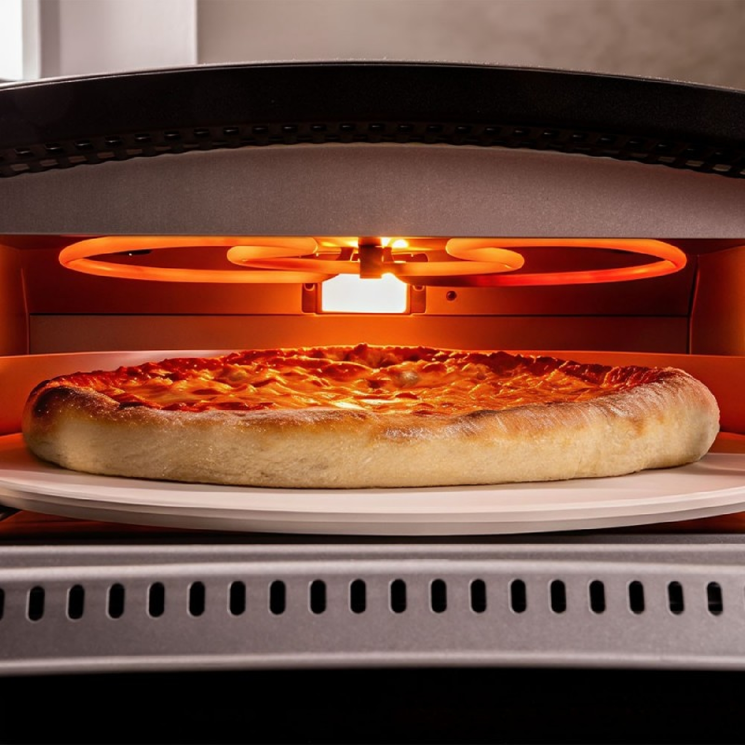 Una pizza se hornea en una piedra dentro de un horno eléctrico brillante y calentado.