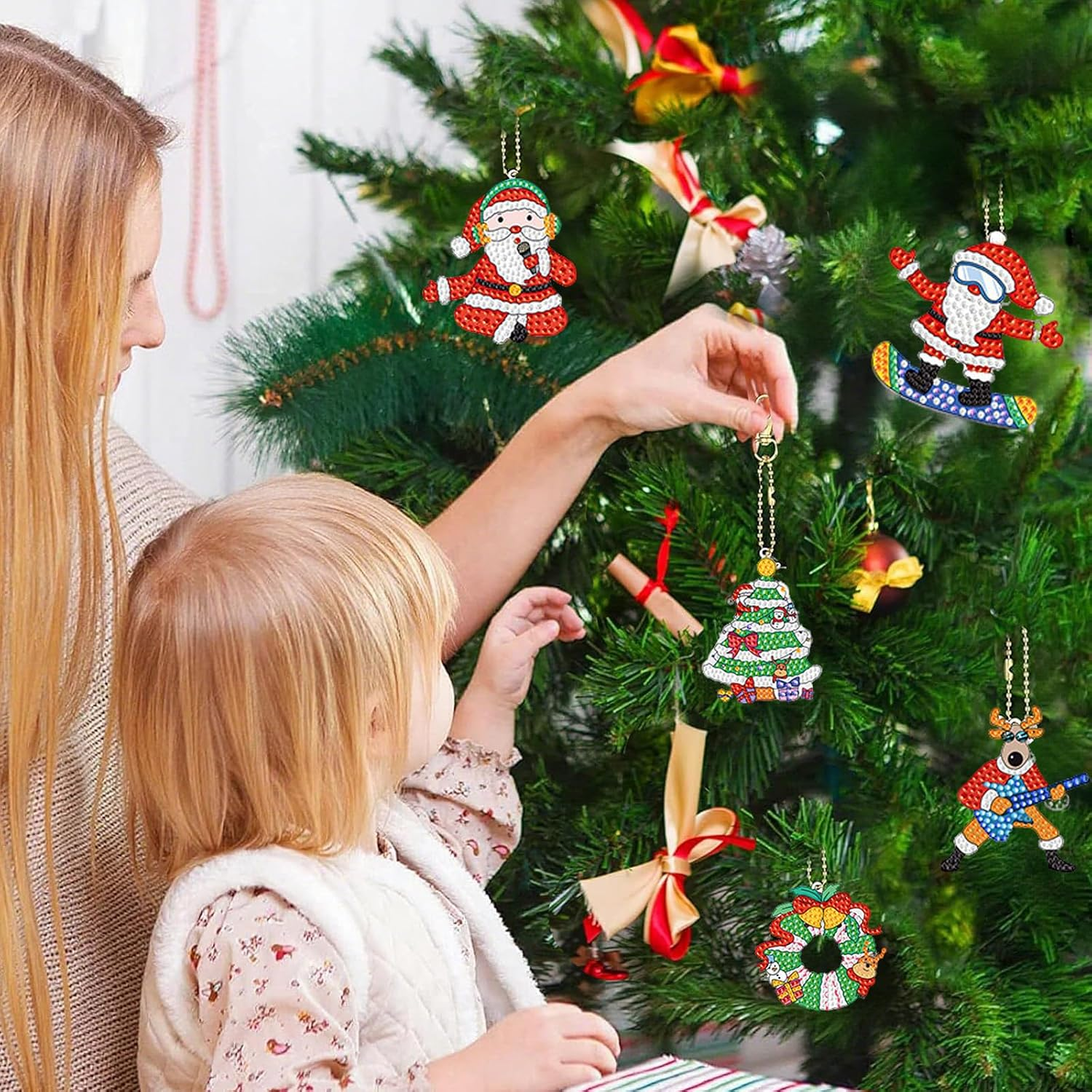Eine Mutter und ein Kind hängen funkelnde Diamant-Kunst-Christbaumkugeln an einen geschmückten Tannenbaum.