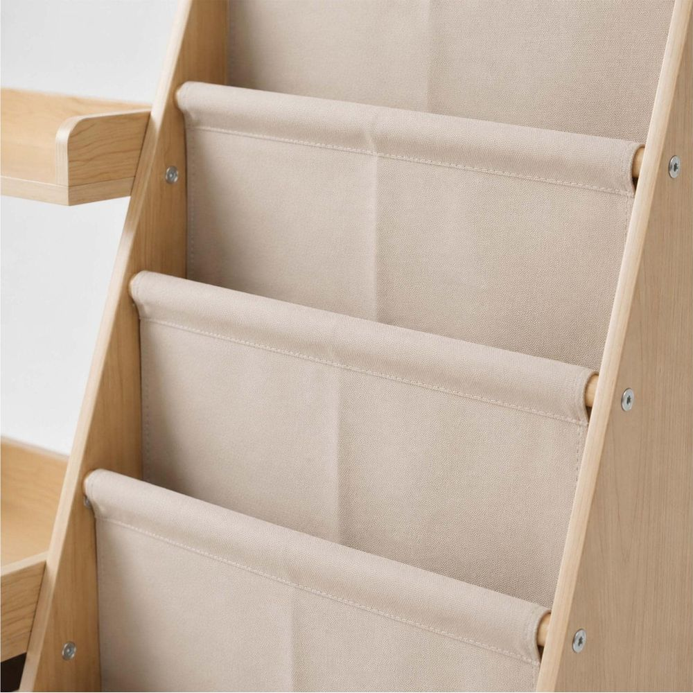 Ein hölzernes Bücherregal mit drei beige Stofftaschen zur Aufbewahrung von Kinderbüchern.