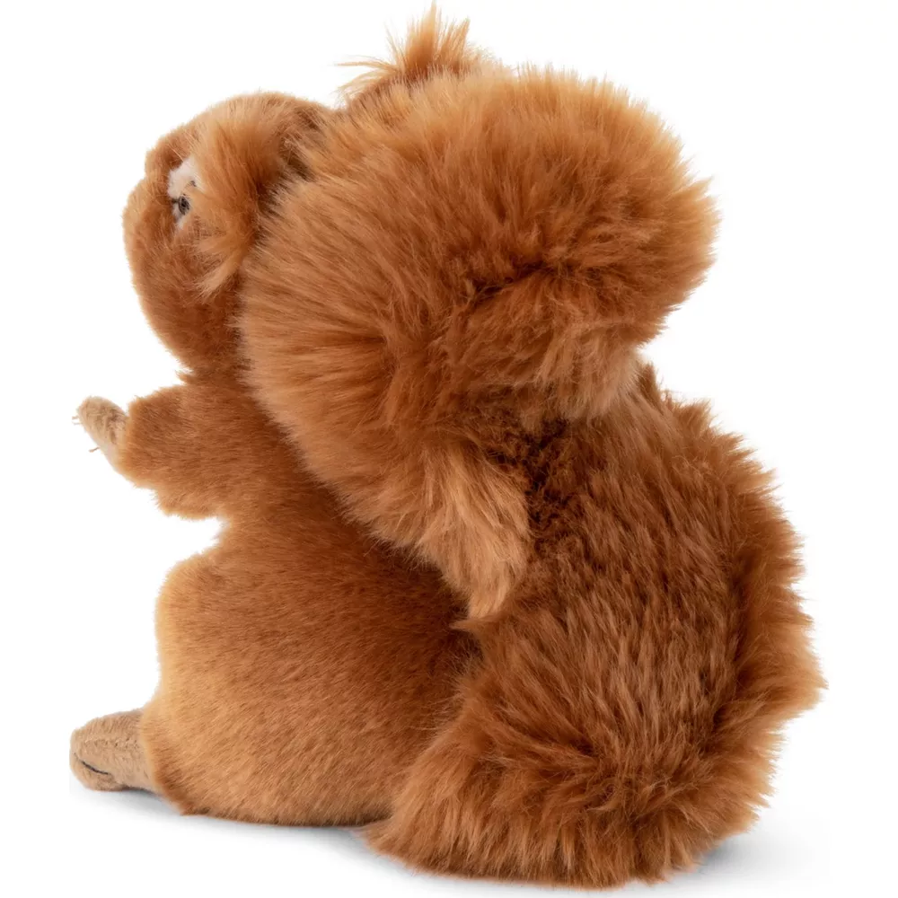 Una ardilla de peluche está sentada sobre un fondo blanco, mostrando su pelo largo y espeso.