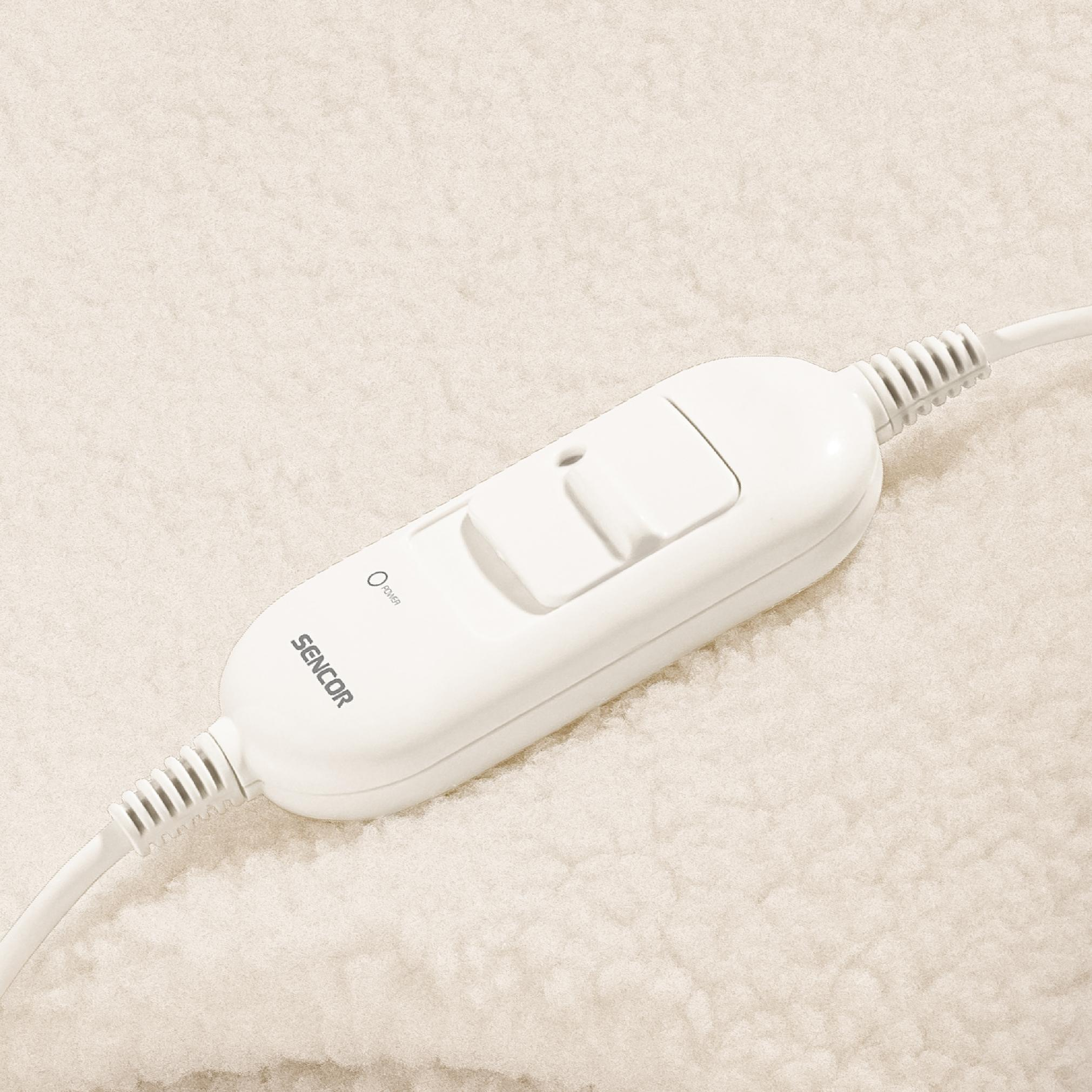 Un controller Sencor bianco con cavo si trova su una coperta termica beige.