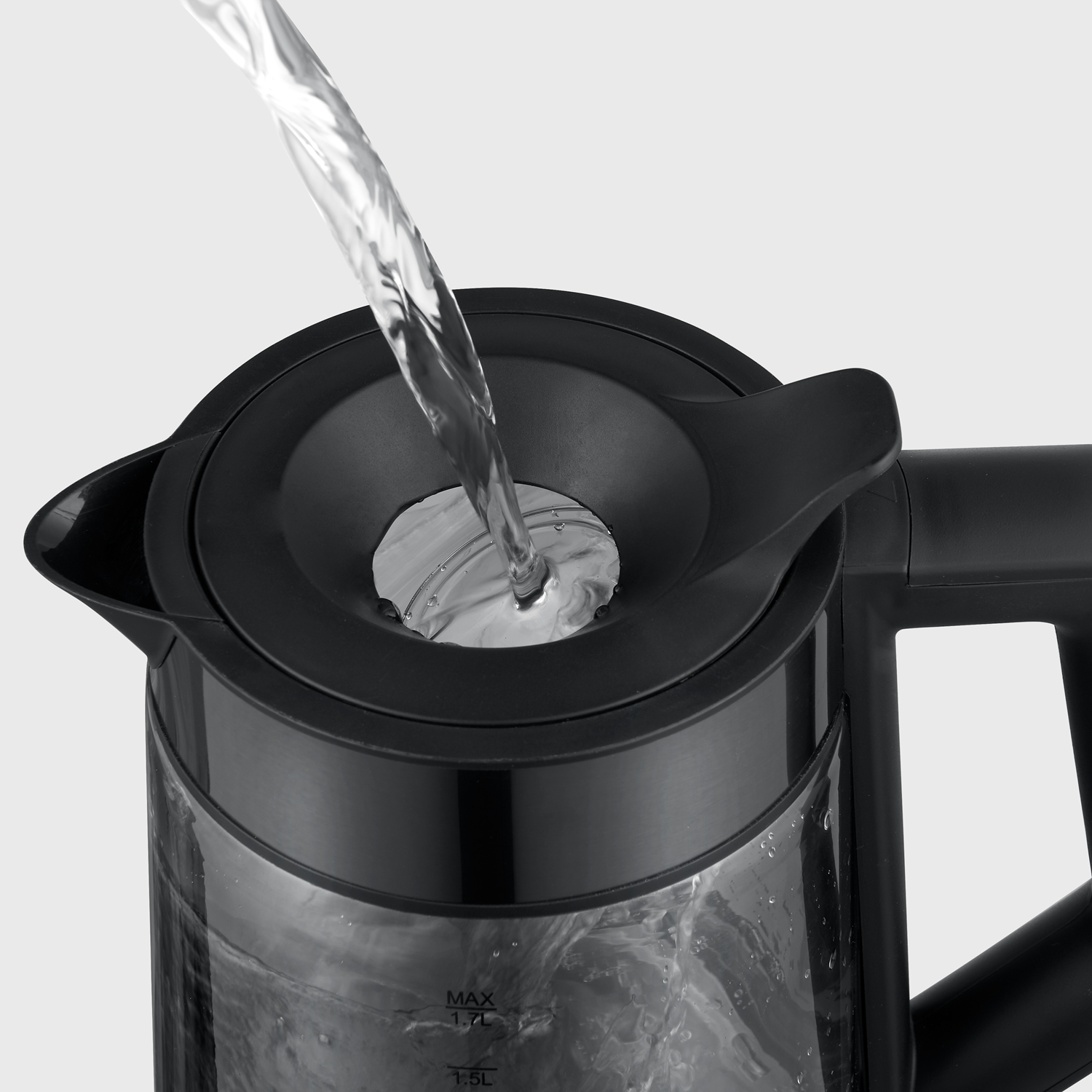 Acqua versata nell'apertura superiore di un bollitore nero e trasparente su sfondo grigio chiaro.