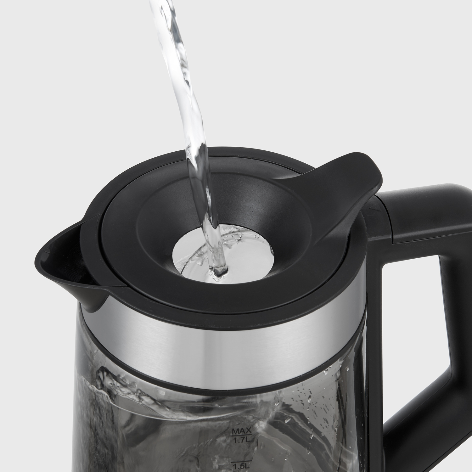 L'acqua viene versata nell'apertura di un bollitore elettrico nero e argento.