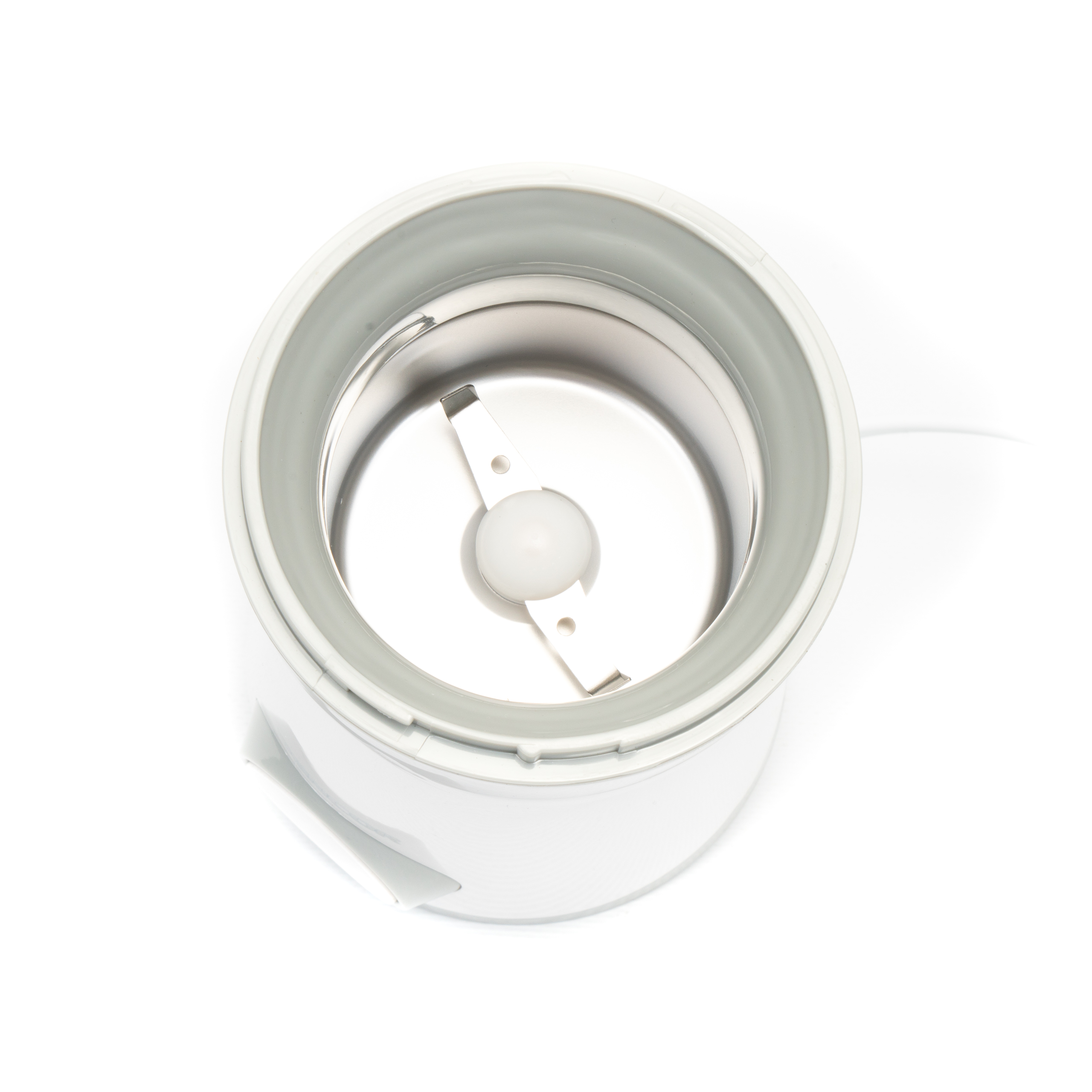 Top-down-Ansicht einer Kaffeemühle mit weißen Rändern und silberner Edelstahlkammer samt Metallklingen.
