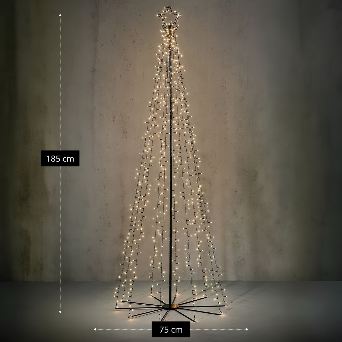 Ein kegelförmiger Drahtgitter-Weihnachtsbaum mit warmweißen Lichtern, 185 cm hoch und 75 cm breit, vor einer rustikalen Wand.
