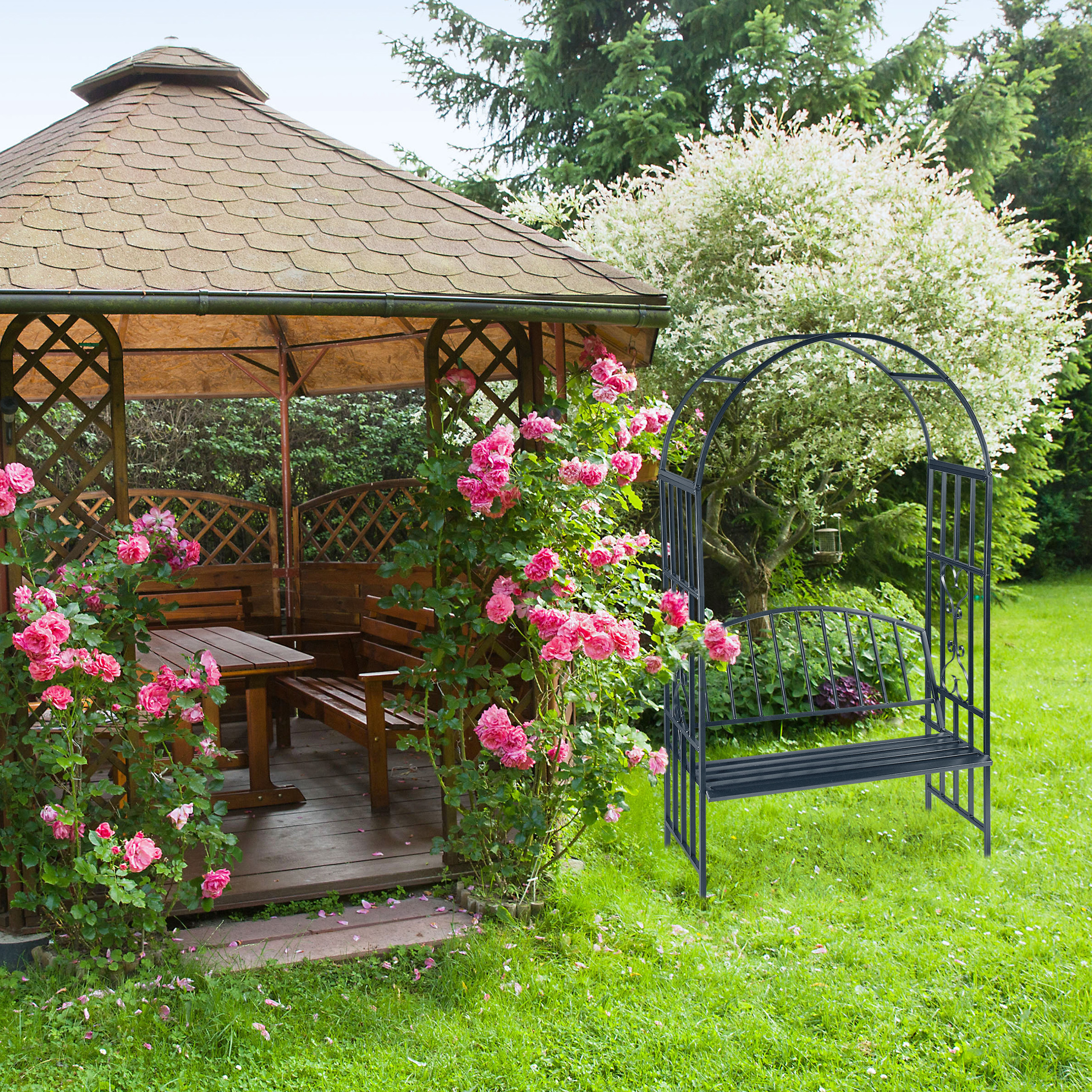 Ein hölzerner Gartenpavillon mit rosa Rosen und eine schwarze Gartenbank mit Bogen im grünen Garten.