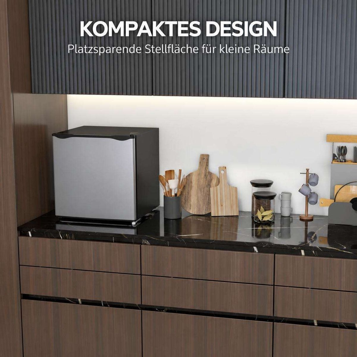 Kompakter kleiner Kühlschrank auf einer dunklen Küchenarbeitsplatte mit holzfarbenen Schränken.