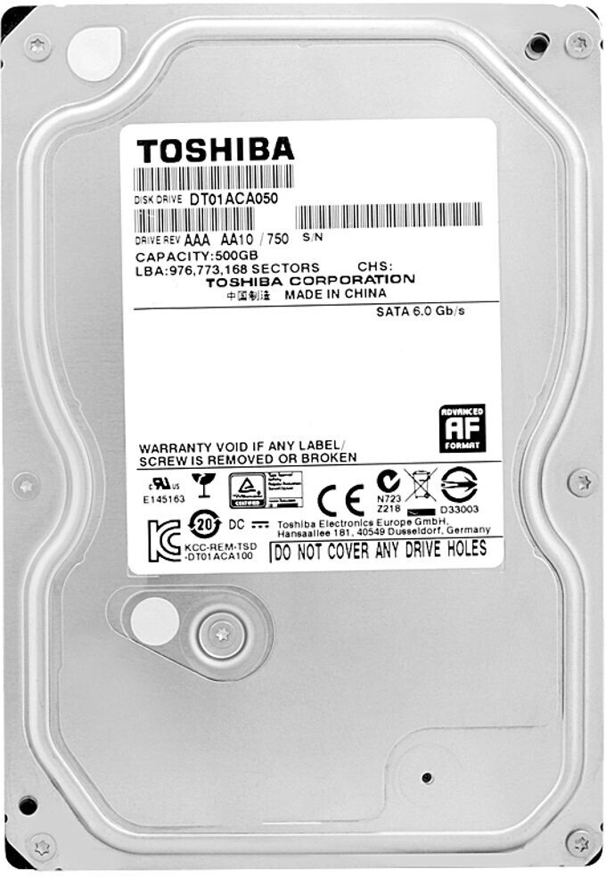 Oberansicht einer Toshiba 500GB Festplatte mit Etikett, Strichcodes und Sicherheitssymbolen auf einem Metallgehäuse.