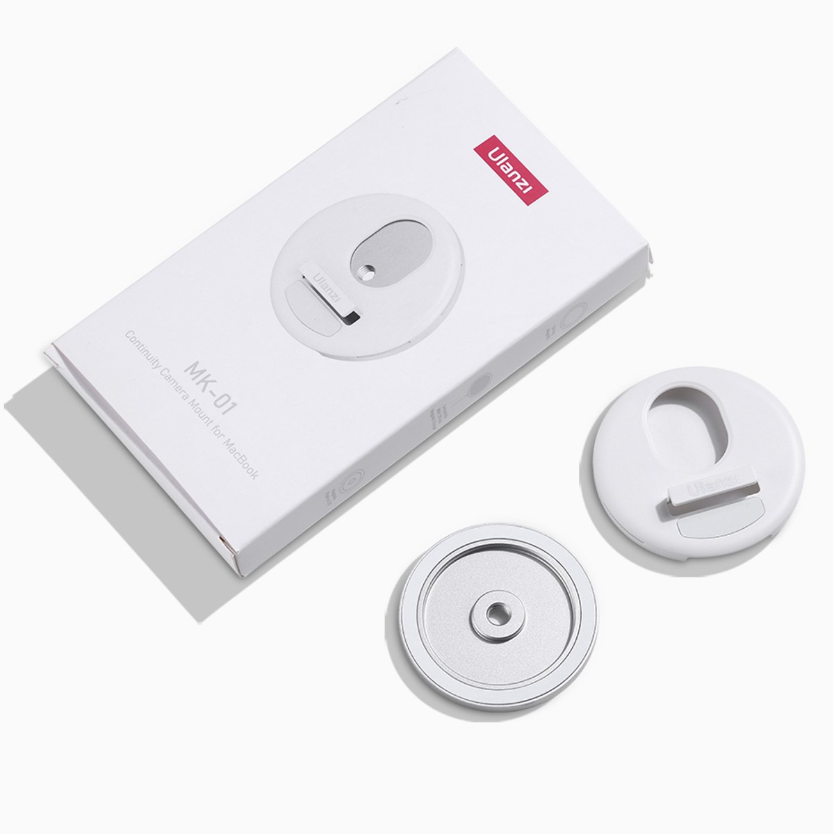 Witte Ulanzi MK-01 Continuity camerabevestigingsdoos met twee ronde accessoires ervoor op een wit oppervlak.