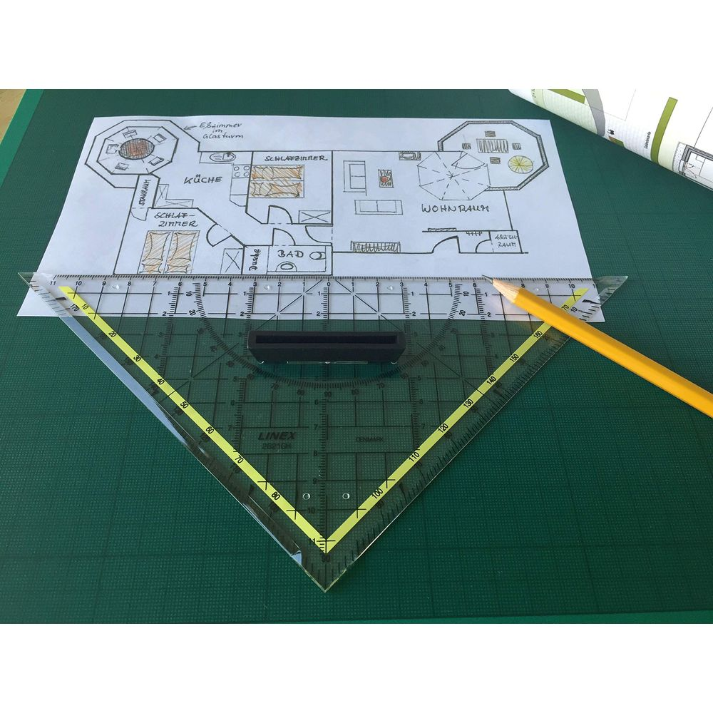 Ein Architekturplan auf einer grünen Unterlage mit einem Geodreieck und einem gelben Bleistift.