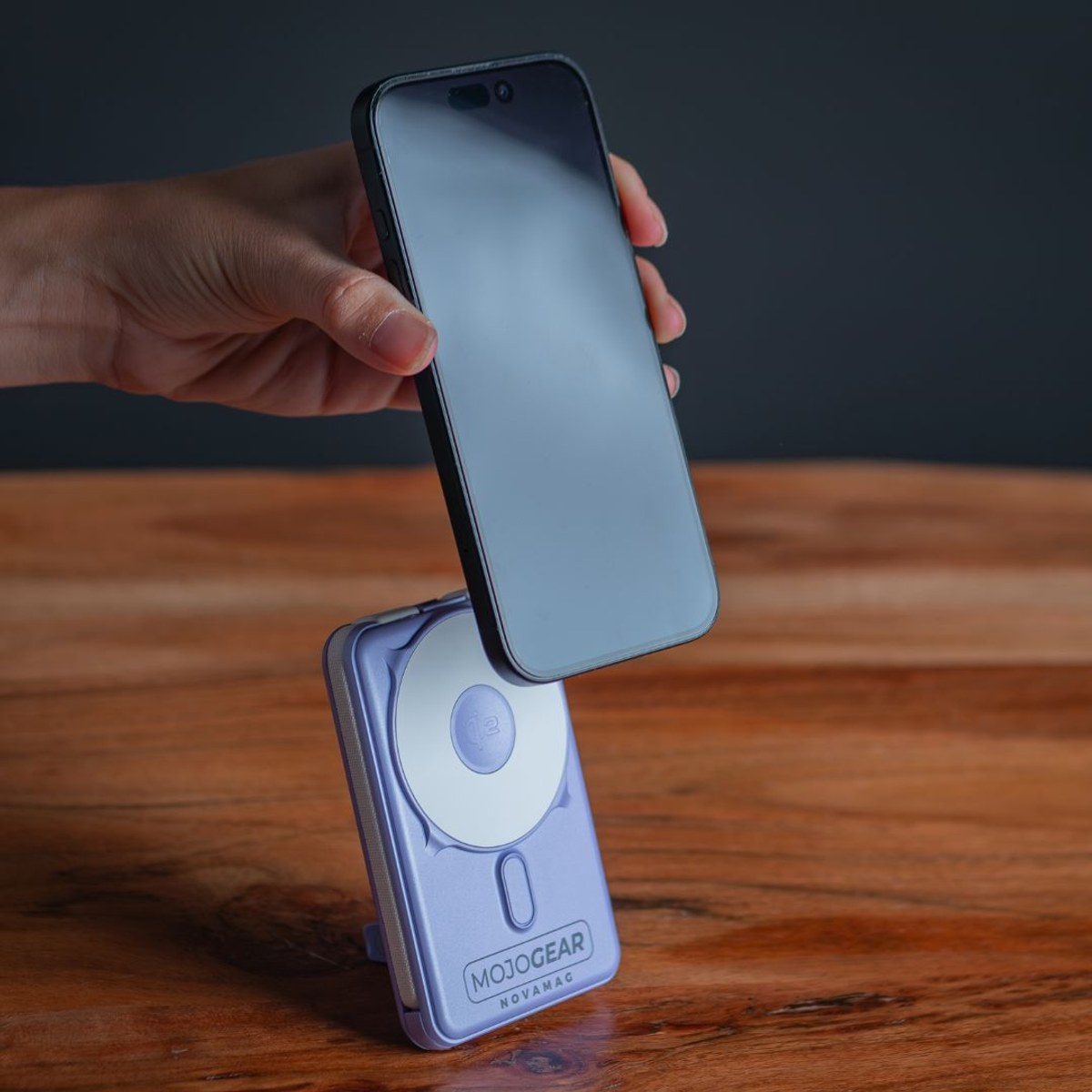 Mano tiene uno smartphone sopra un power bank viola Mojogear Novamag.