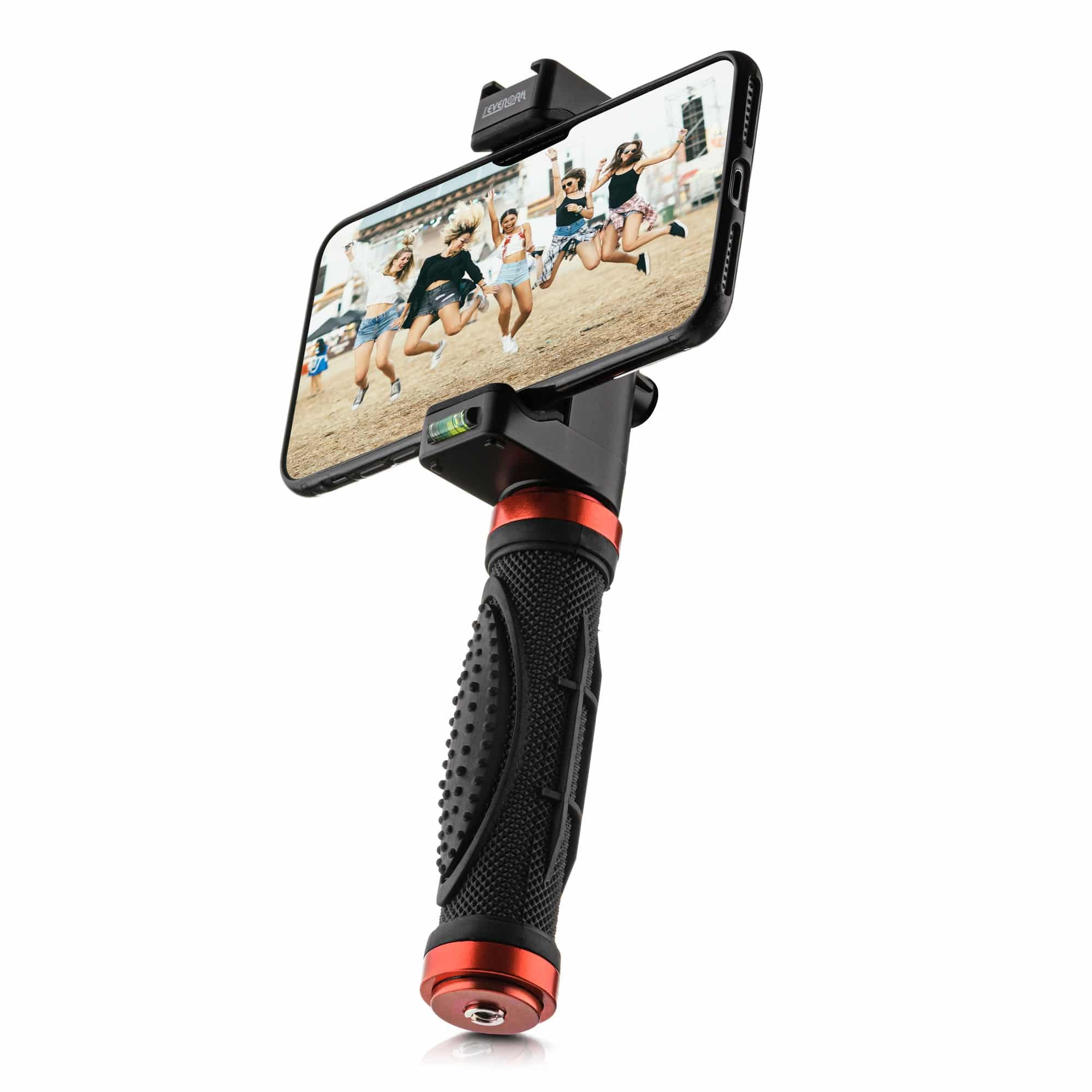 Ein schwarzer Smartphone-Gimbal mit rotem Ring hält ein Telefon, das vier springende Frauen auf sandigem Grund zeigt.