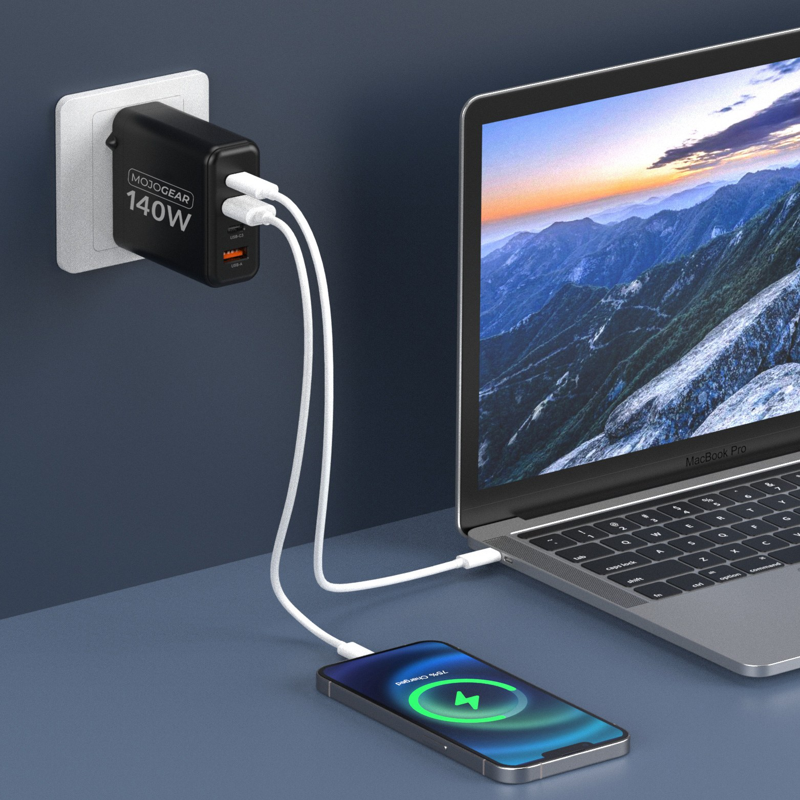 A 140W MojoGear wall charger plugged into an outlet charges a laptop and a smartphone.