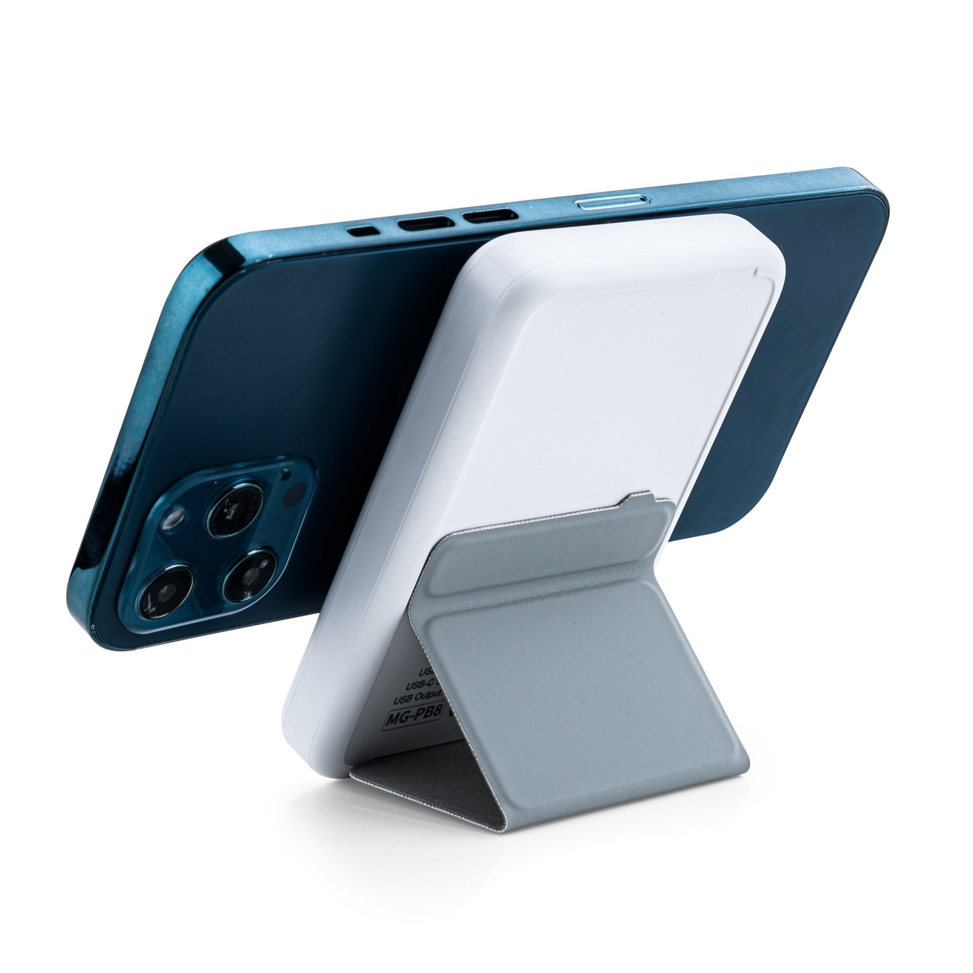 Un smartphone bleu est posé sur une surface blanche par une batterie externe MagSafe blanche avec support pliable.