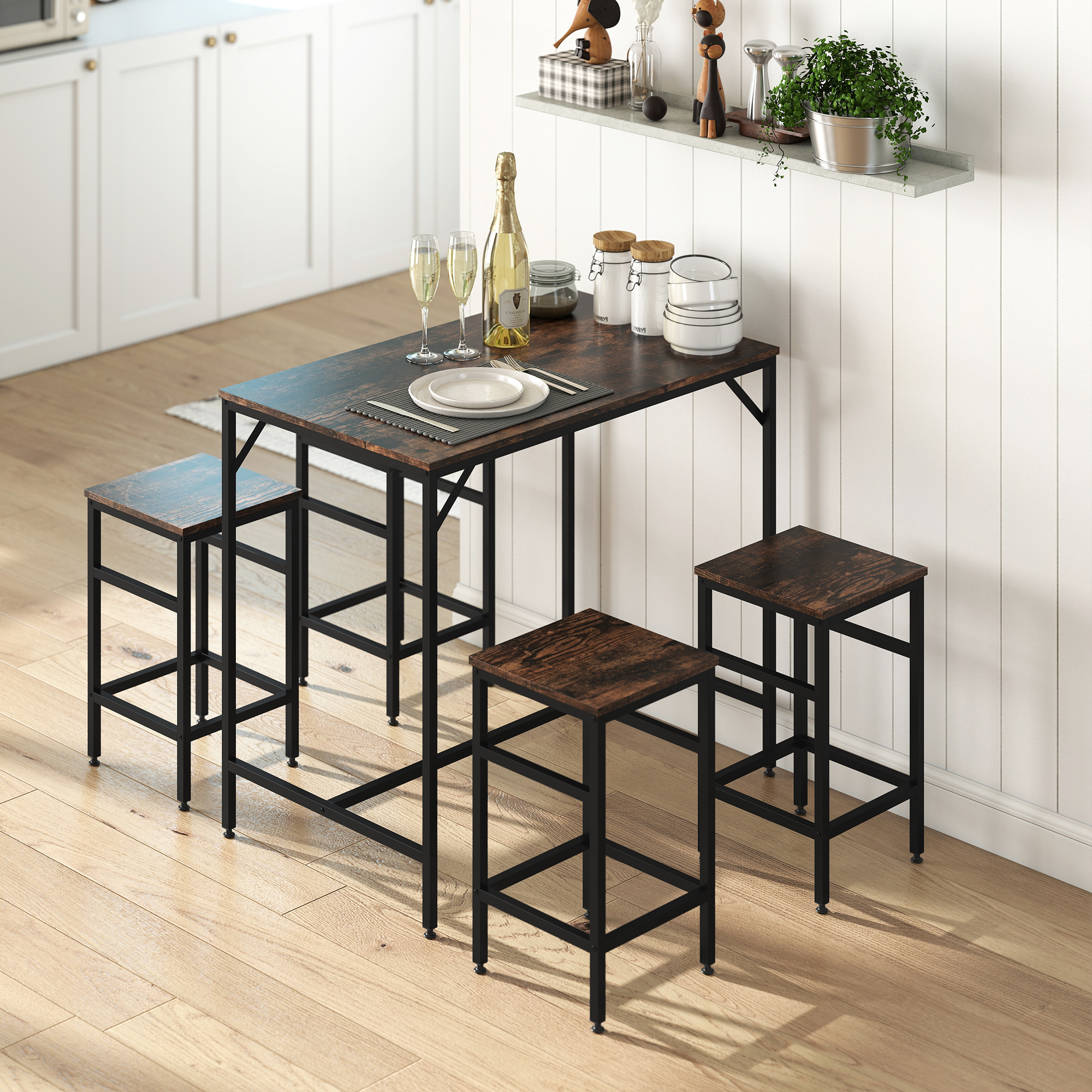 Un piccolo tavolo da pranzo in legno con quattro sgabelli coordinati in cucina, apparecchiato con bicchieri e stoviglie.