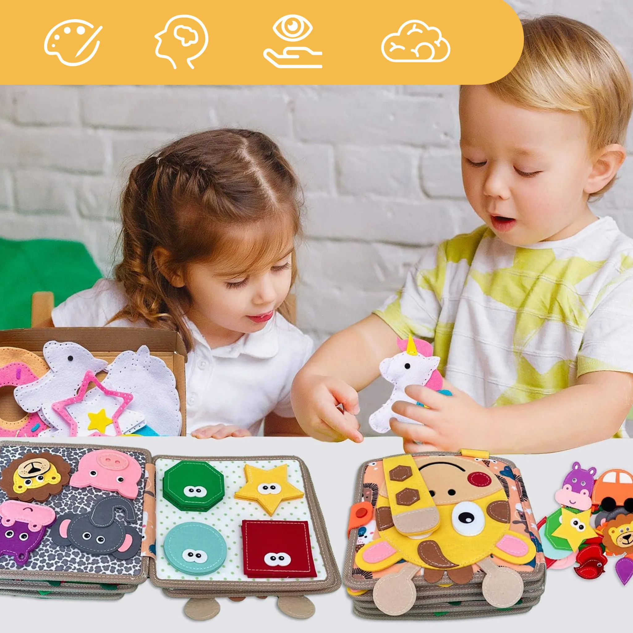Zwei Kleinkinder spielen mit Filzspielzeug und interaktiven Lernbüchern vor einer weißen Backsteinwand.