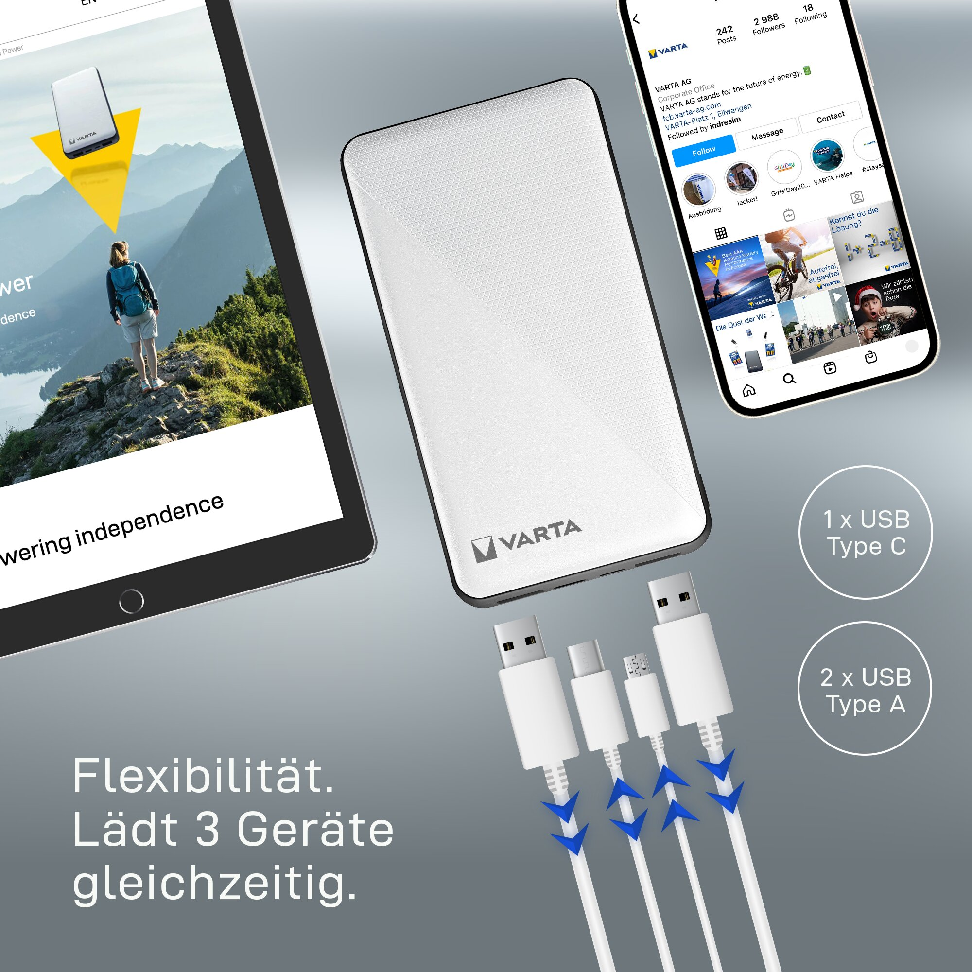 Weiße VARTA Powerbank mit drei angeschlossenen Ladekabeln, umgeben von einem Tablet und einem Smartphone auf grauem Grund.