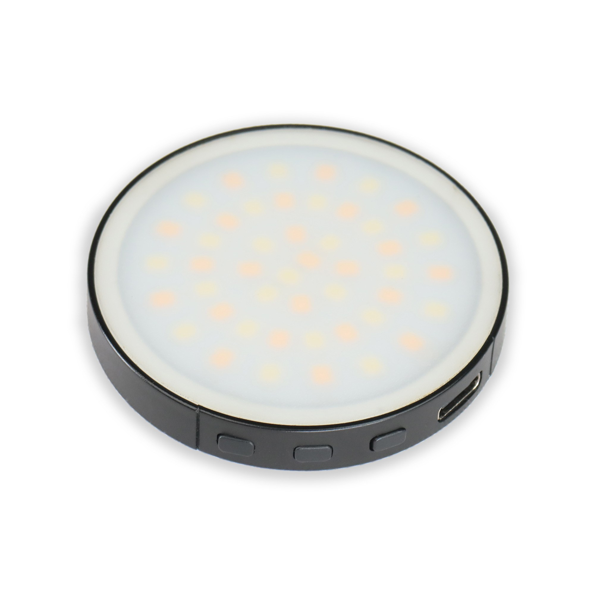 A round black selfie light with a frosted white diffuser and small LED bulbs inside, viewed from an angle.