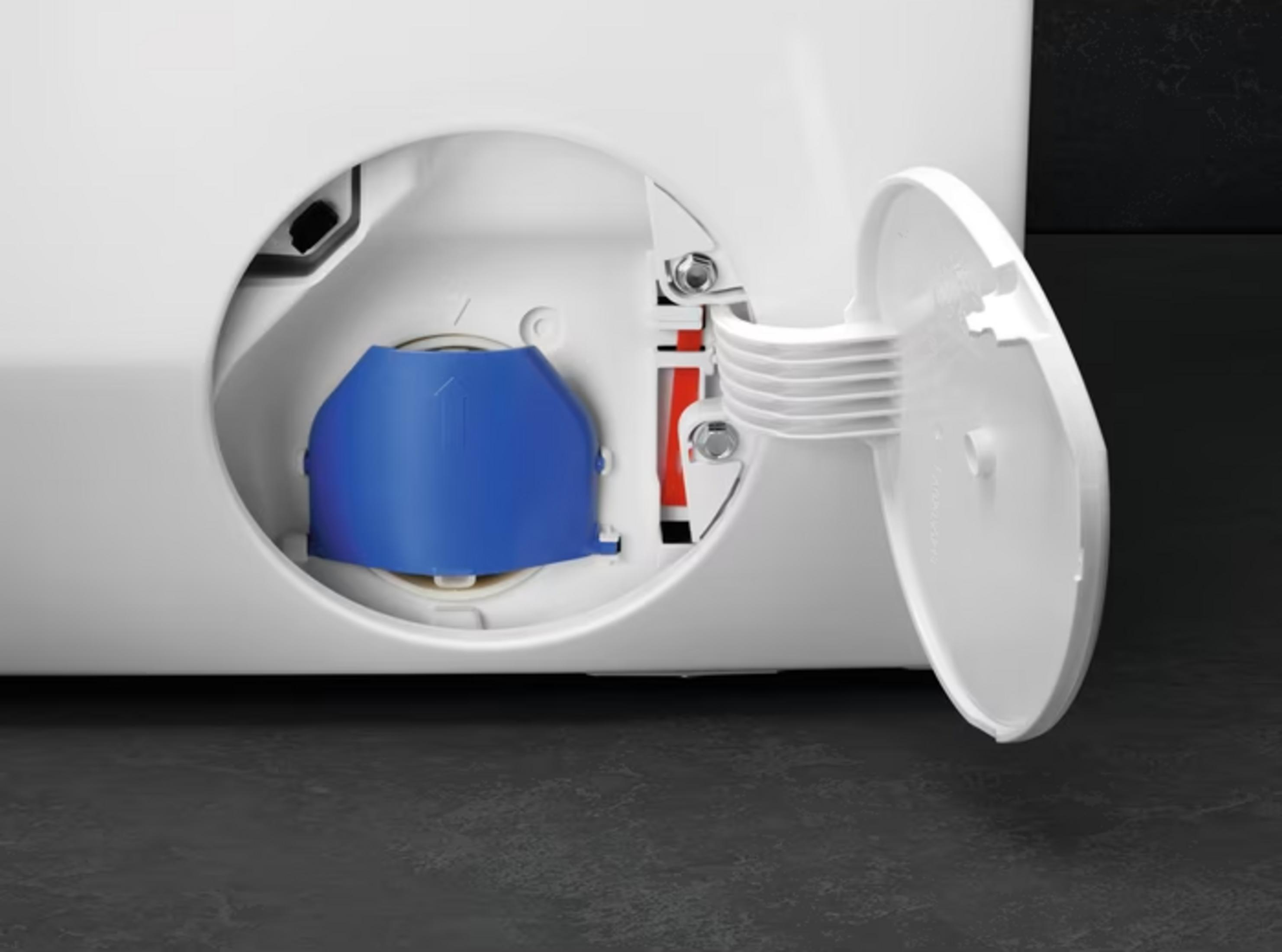 Otwarte białe drzwiczki pralki ukazują niebieską wkładkę i czerwoną część w filtrze.