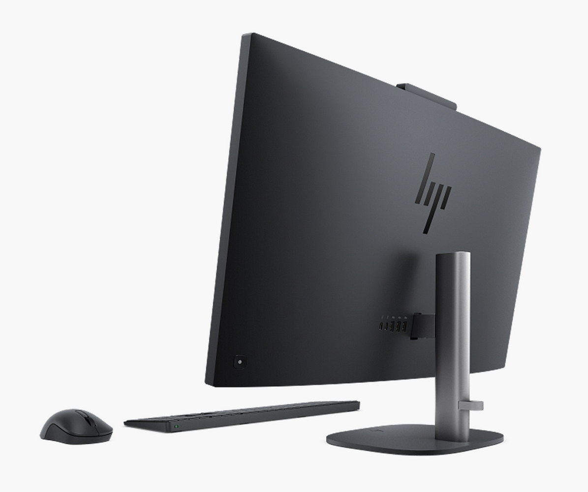 Un monitor HP nero visto da dietro, con supporto argentato, tastiera nera e mouse per computer.