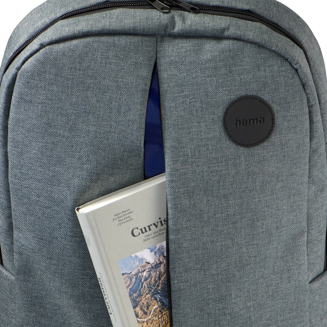 Zaino grigio Hama con uno scomparto aperto che contiene un libro.