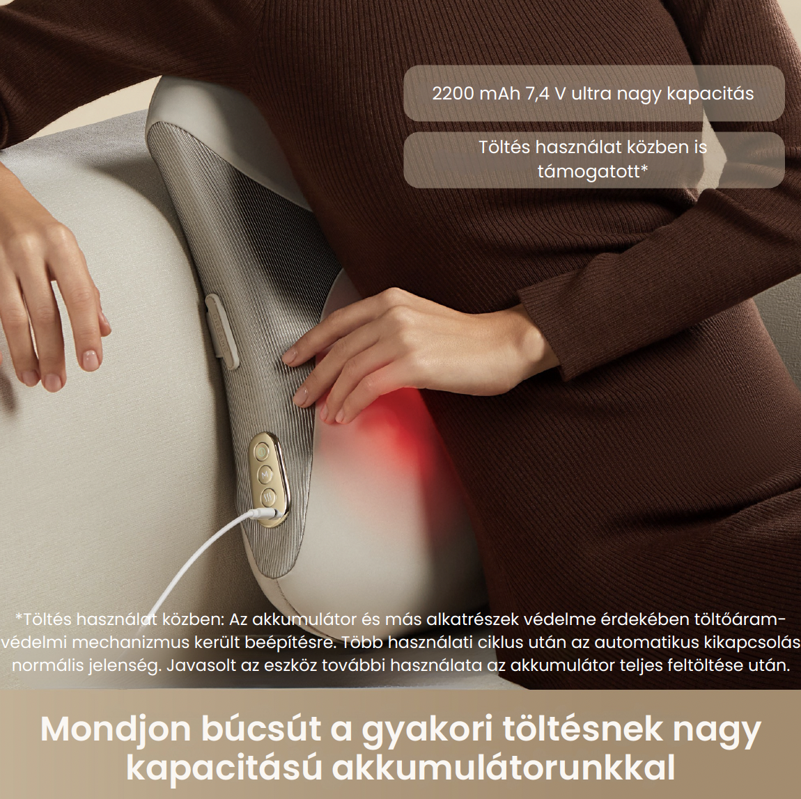 Egy személy egy szürke, vezeték nélküli hátmasszírozót használ pirosan izzó fűtésfunkcióval a kanapén.