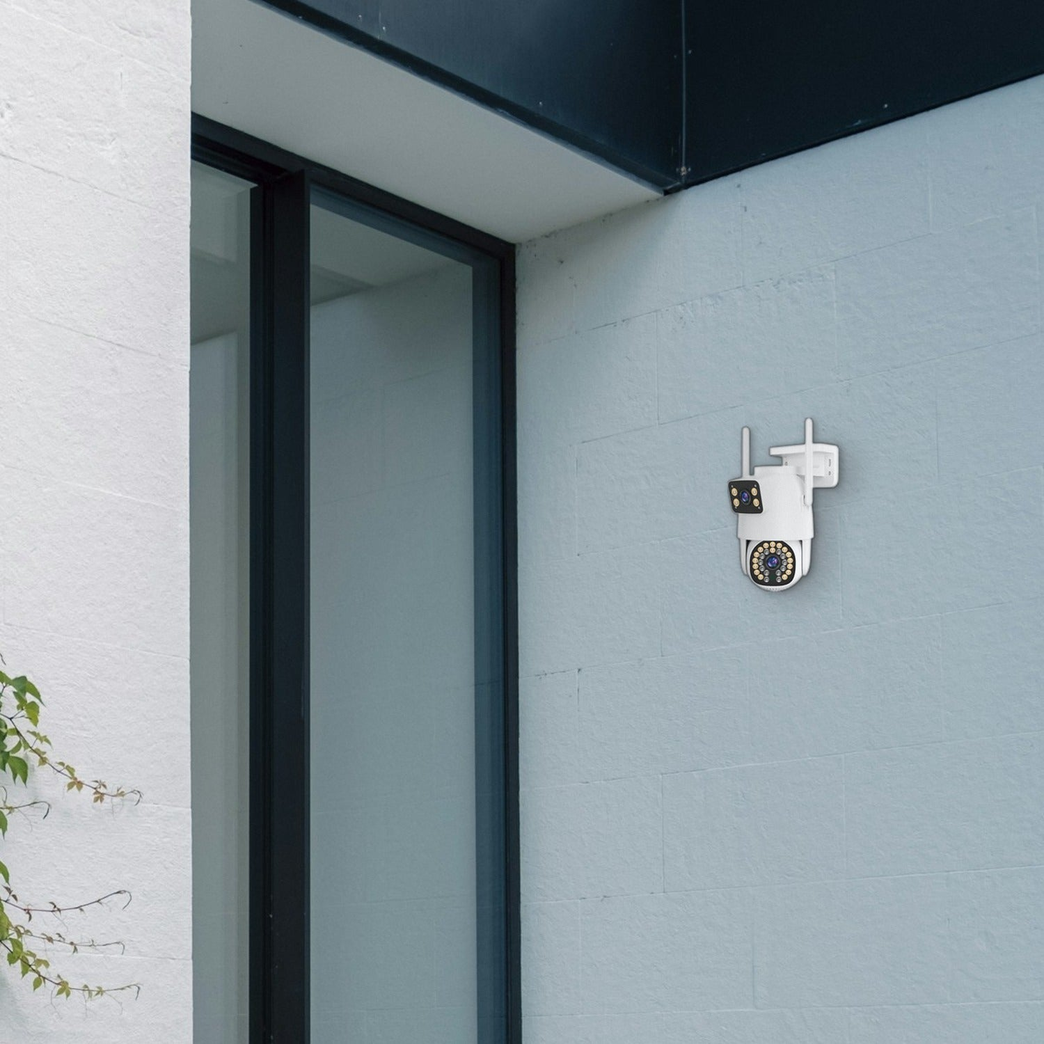 Una cámara de seguridad blanca está montada en una pared azul claro al lado de una puerta de cristal.