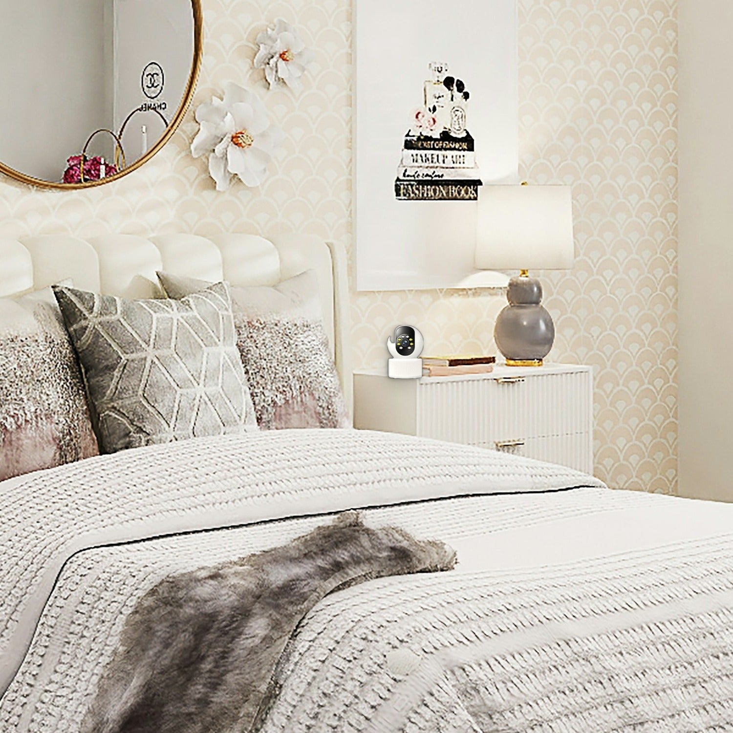 Acogedor dormitorio con cama blanca, cojines, espejo redondo, decoración de pared, mesita de noche y una cámara.