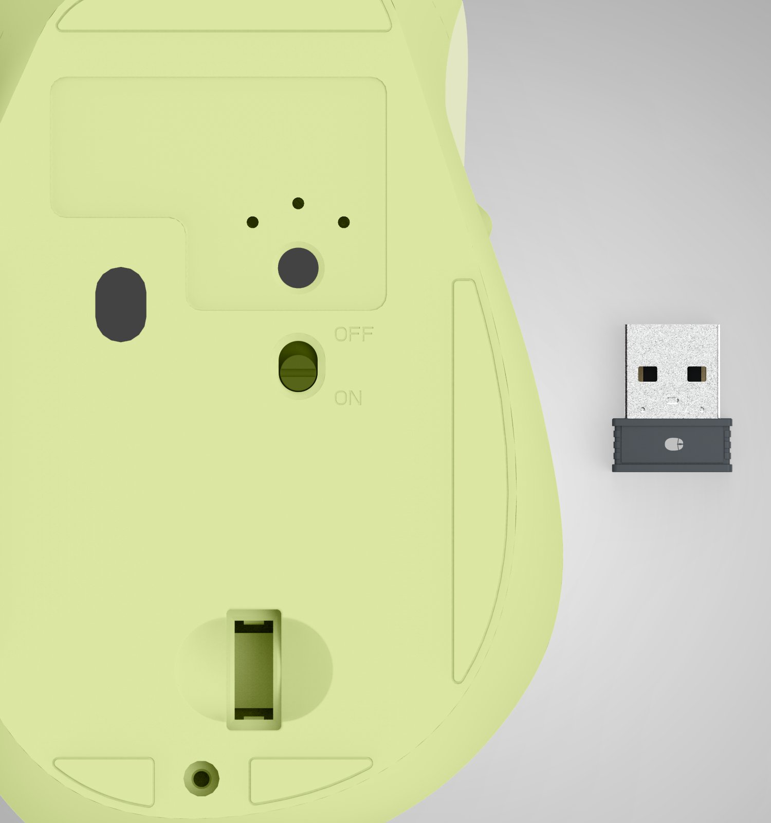 La parte inferiore di un mouse wireless verde chiaro con interruttore e un piccolo ricevitore USB accanto.
