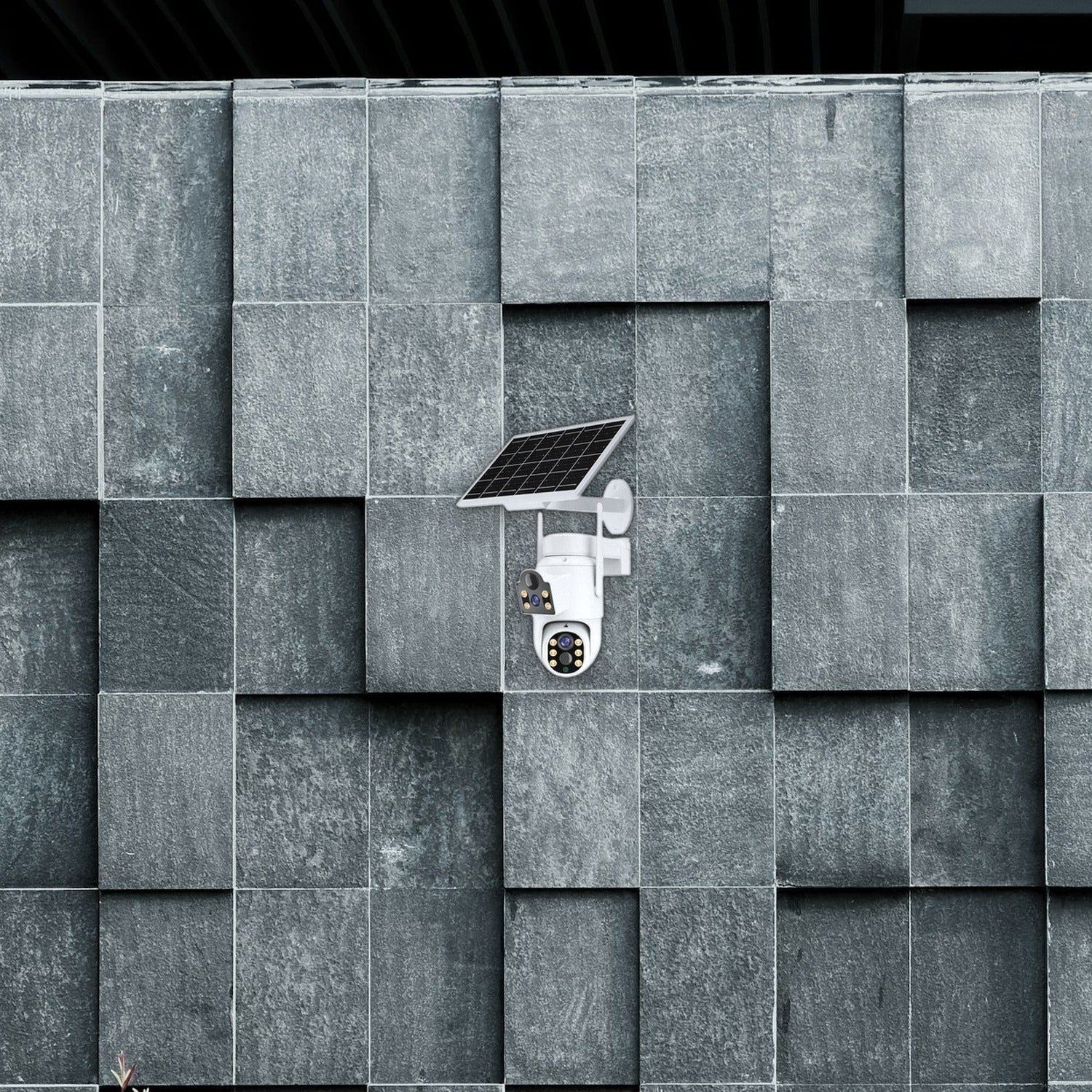 Una cámara de seguridad blanca con panel solar está montada en una pared de piedra gris texturizada.