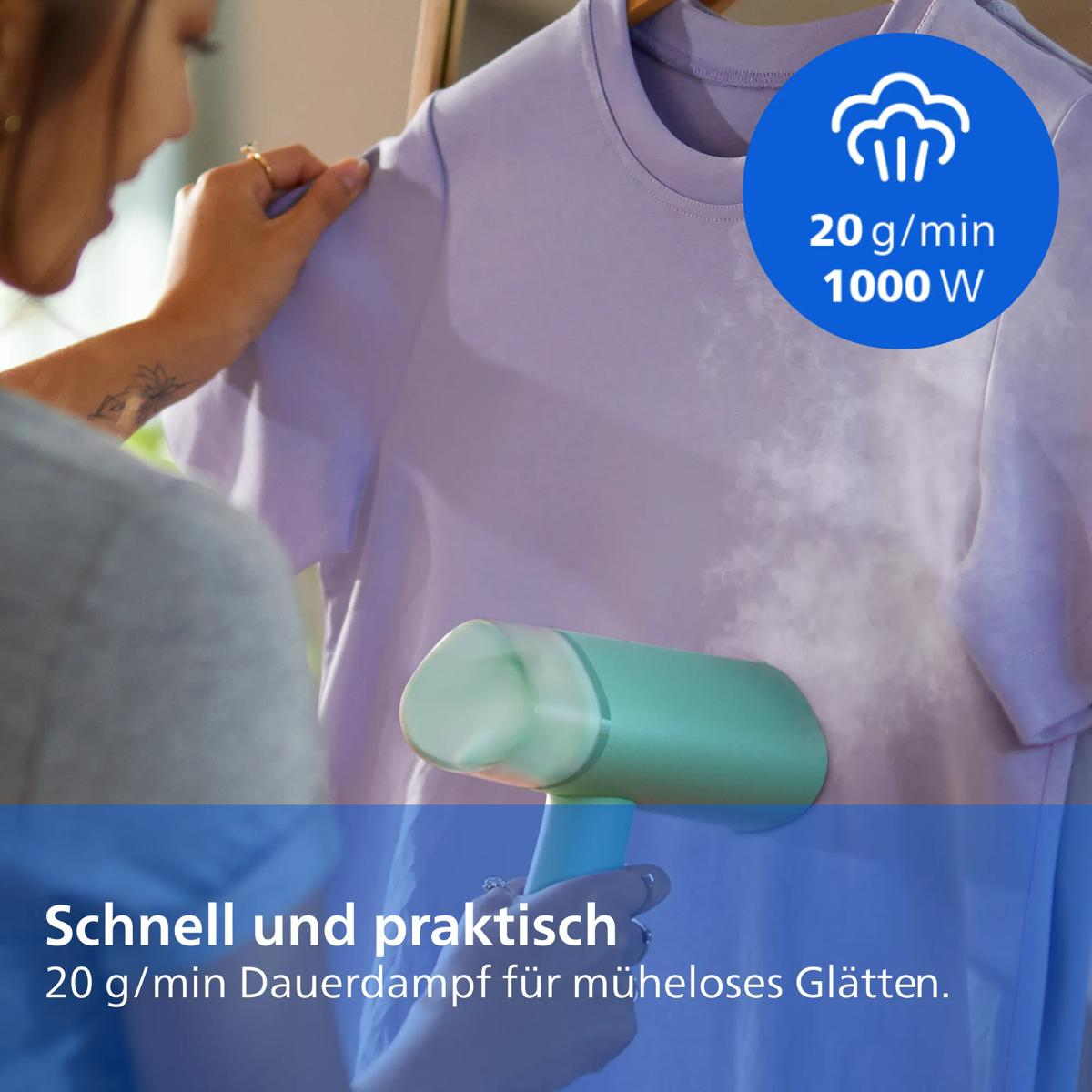 Eine Hand benutzt einen hellblauen Handdampfgarer auf einem lila T-Shirt mit Dampfausstoß.