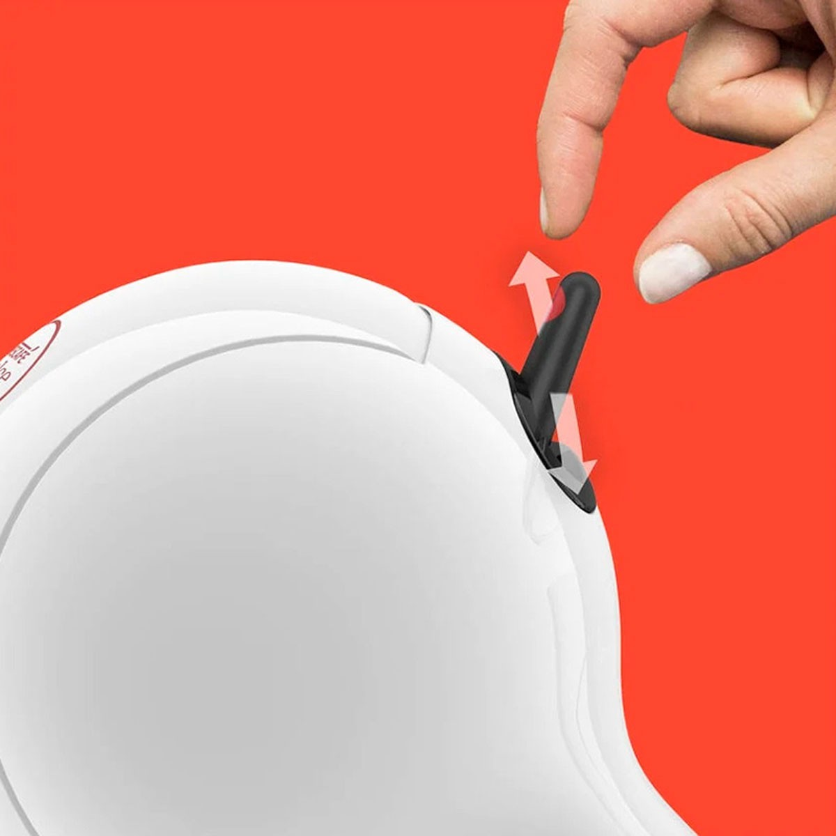 Una mano tira una piccola leva nera su un dispositivo bianco su sfondo rosso.