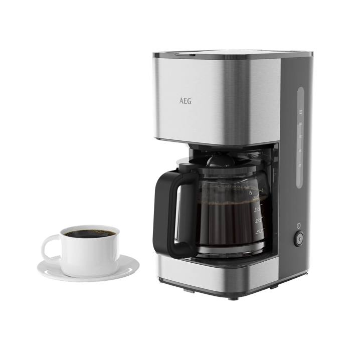 Una cafetera AEG plateada y negra con jarra de vidrio llena junto a una taza blanca de café con platillo.
