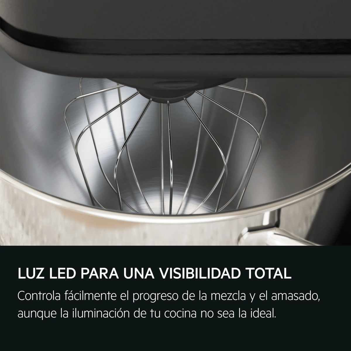 Primer plano de un batidor de varillas dentro de un bol de acero inoxidable.