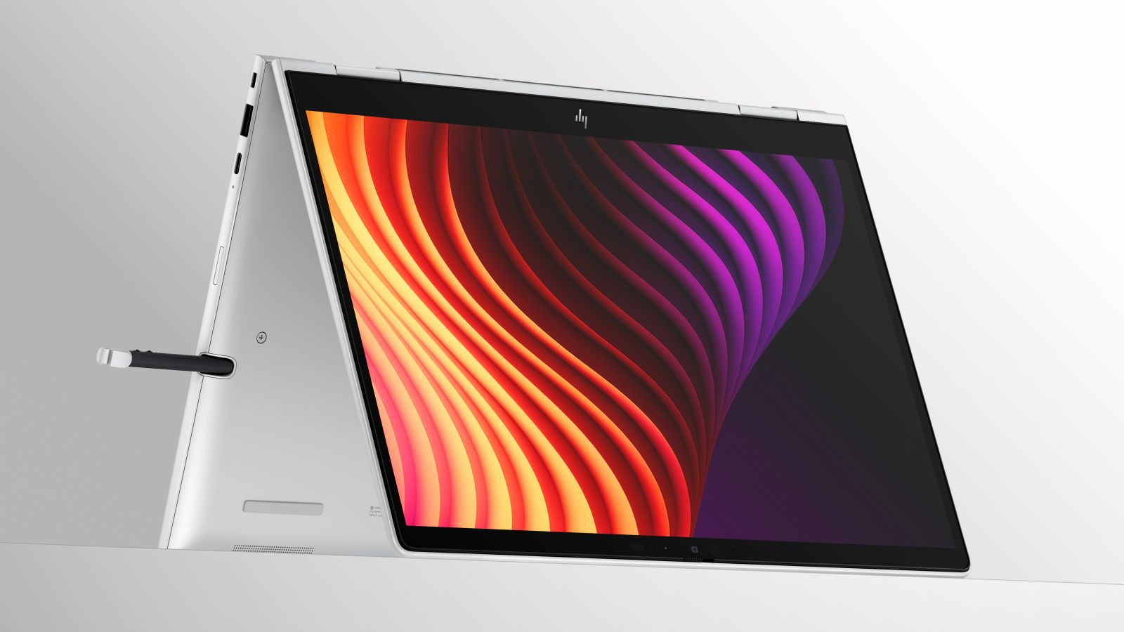 Ein silbernes Convertible-Notebook im Zeltmodus mit buntem abstrakten Hintergrundbild und eingestecktem Eingabestift.