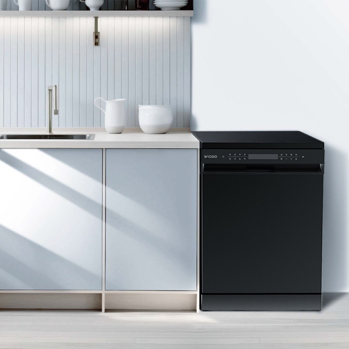 A black dishwasher stands beside light blue kitchen cabinets and a sink counter.