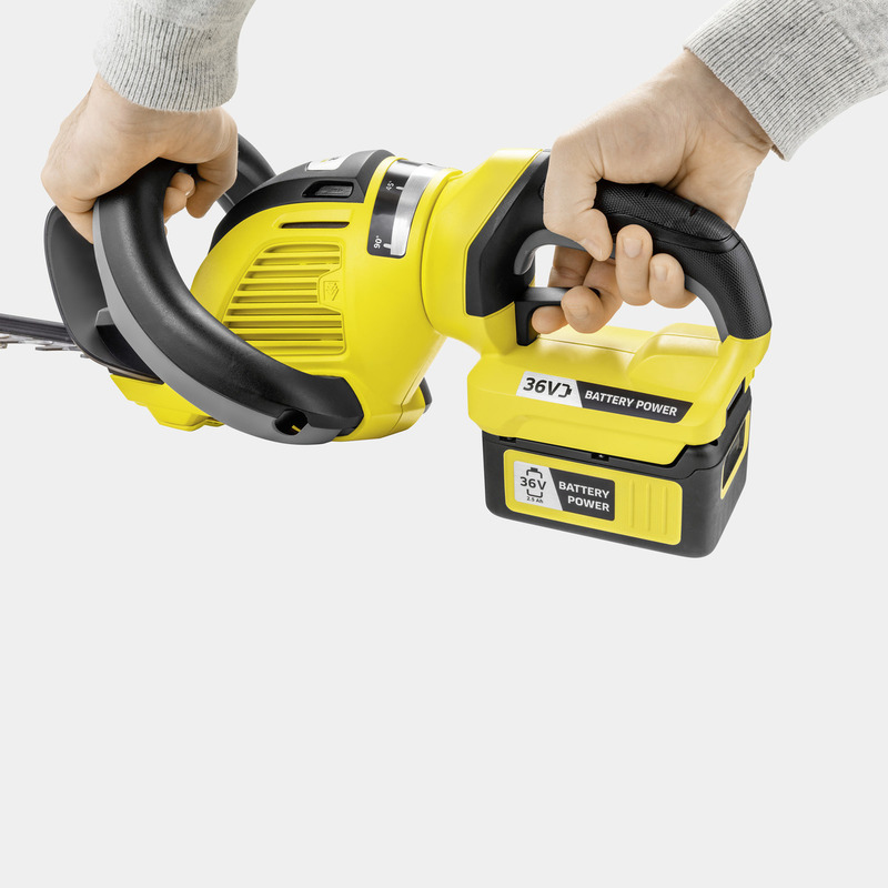 Person hält eine gelb-schwarze Akku-Heckenschere mit 36V Batterie.