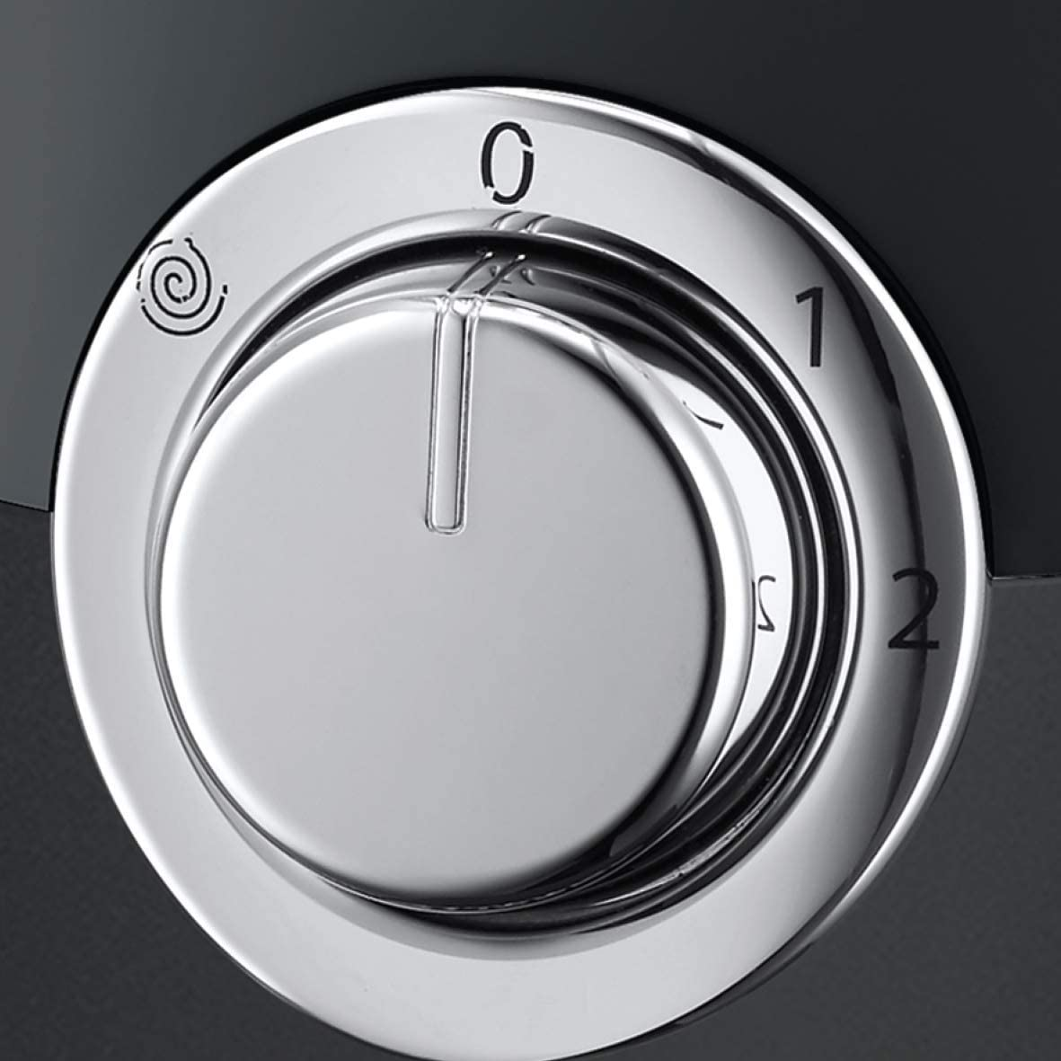 Un dial giratorio plateado con ajustes 0, 1, 2 y un icono sobre fondo negro.