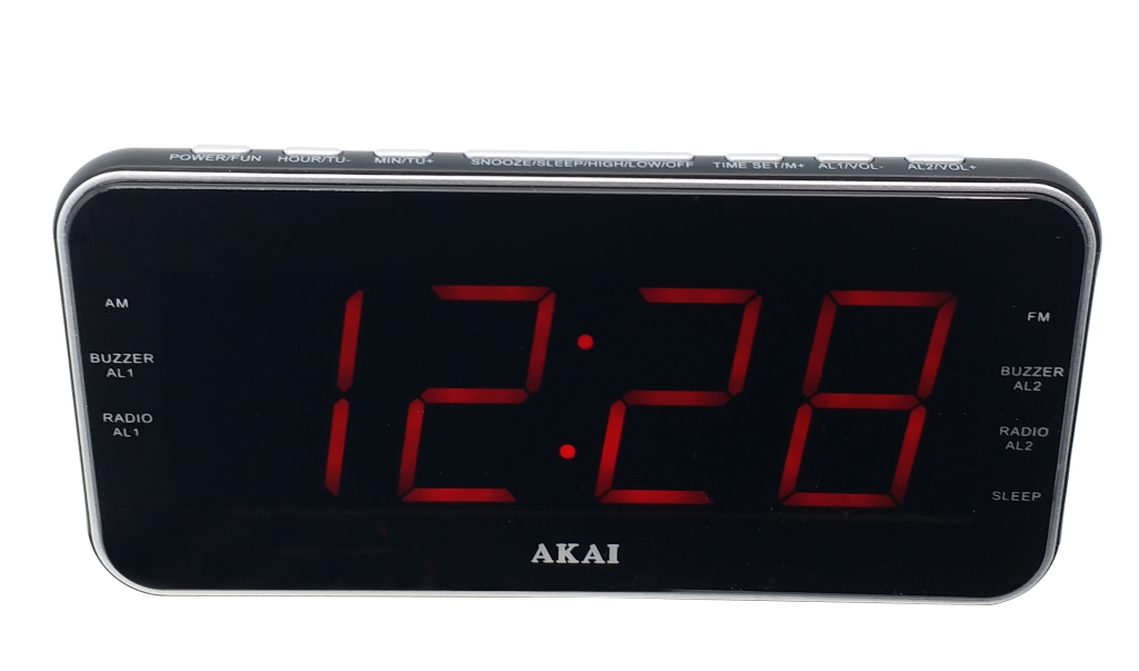 Una sveglia digitale Akai nera con display LED rosso che mostra l'ora 12:28, isolata su sfondo bianco.