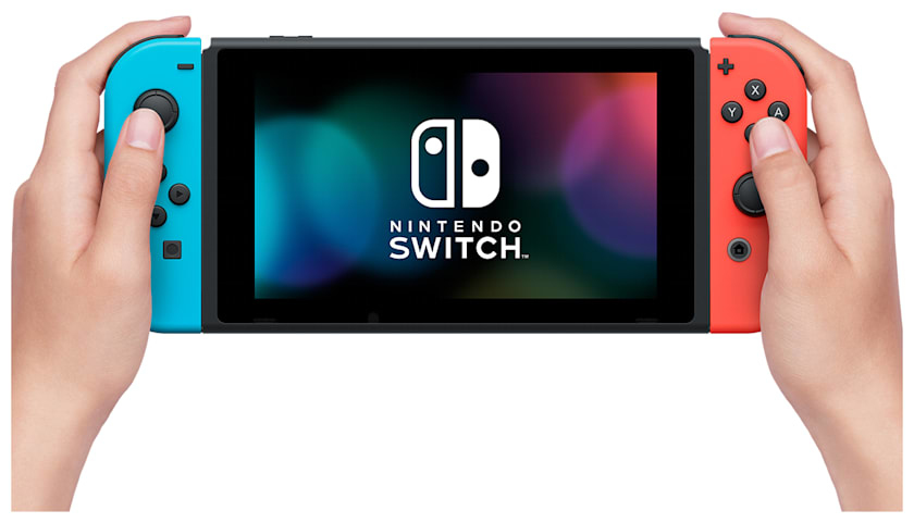 Mani che tengono una console Nintendo Switch con controller Joy-Con blu e rossi su sfondo bianco.